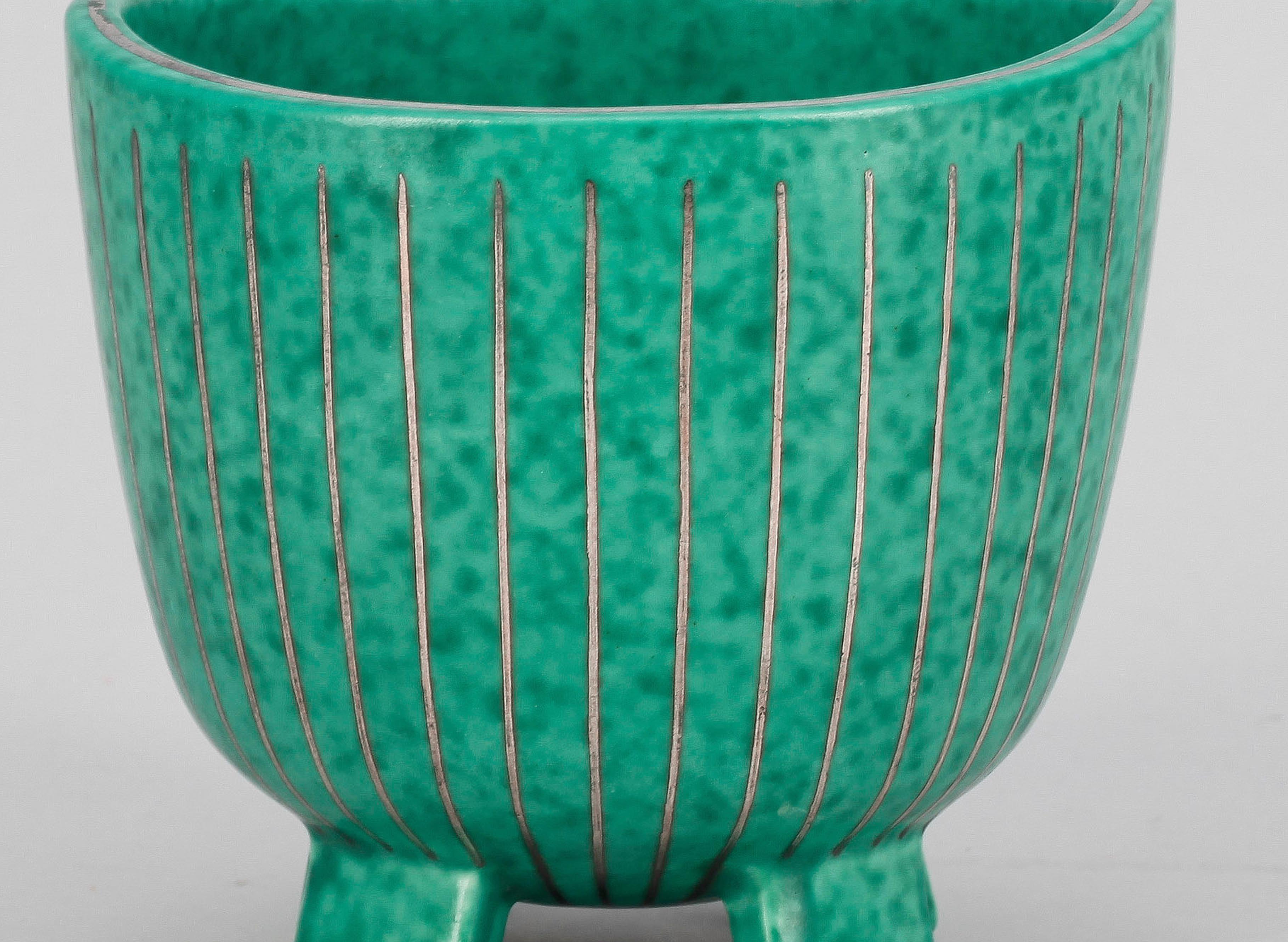 A pot in ceramic with hand made silver inlay from the 1940s Argenta collection made by Wilhelm Kåge for Gustavsberg, signature underneath.
 The now iconic argenta stoneware collection, with its green glaze and silver decoration, is one of wilhelm