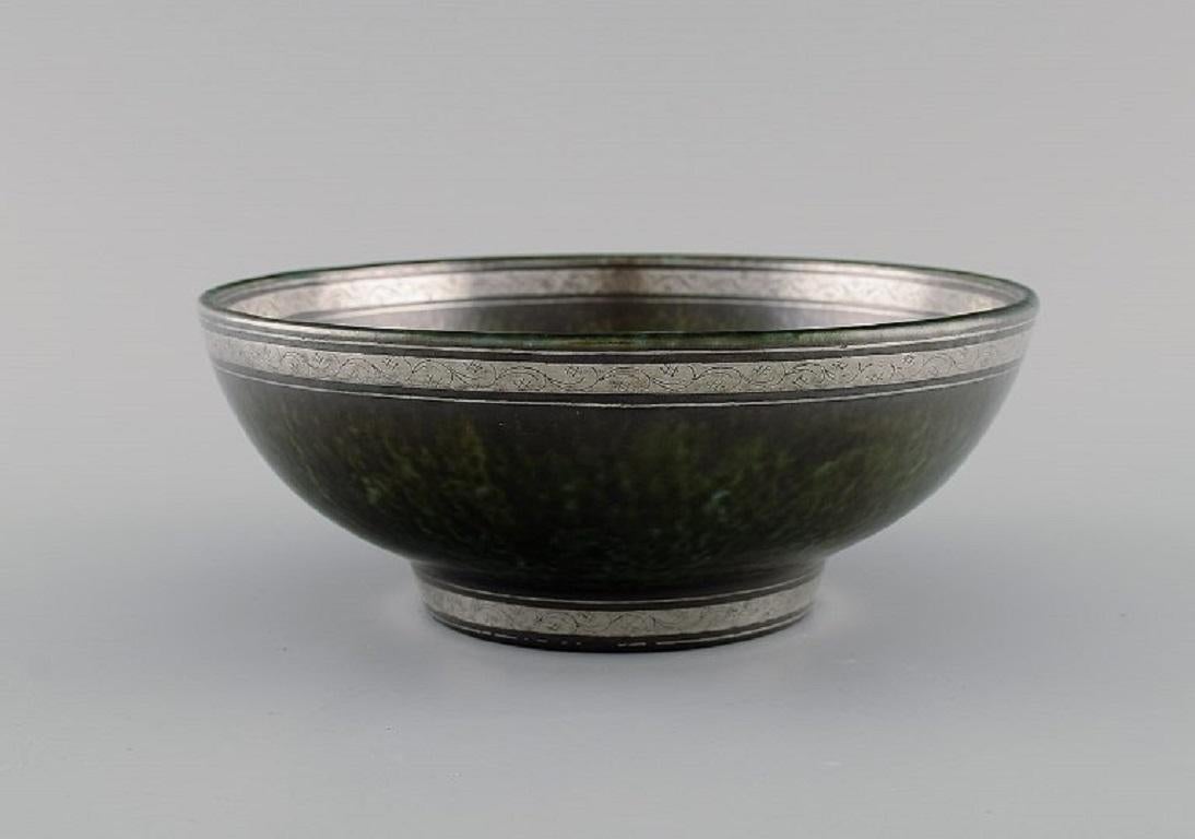 Wilhelm Kåge (1889-1960) for Gustavsberg. 
Argenta Art Deco bowl in glazed ceramics. Beautiful glaze in shades of dark green with silver inlay. 
Dated 1937.
Measures: 17.5 x 7 cm.
In excellent condition.
Stamped.