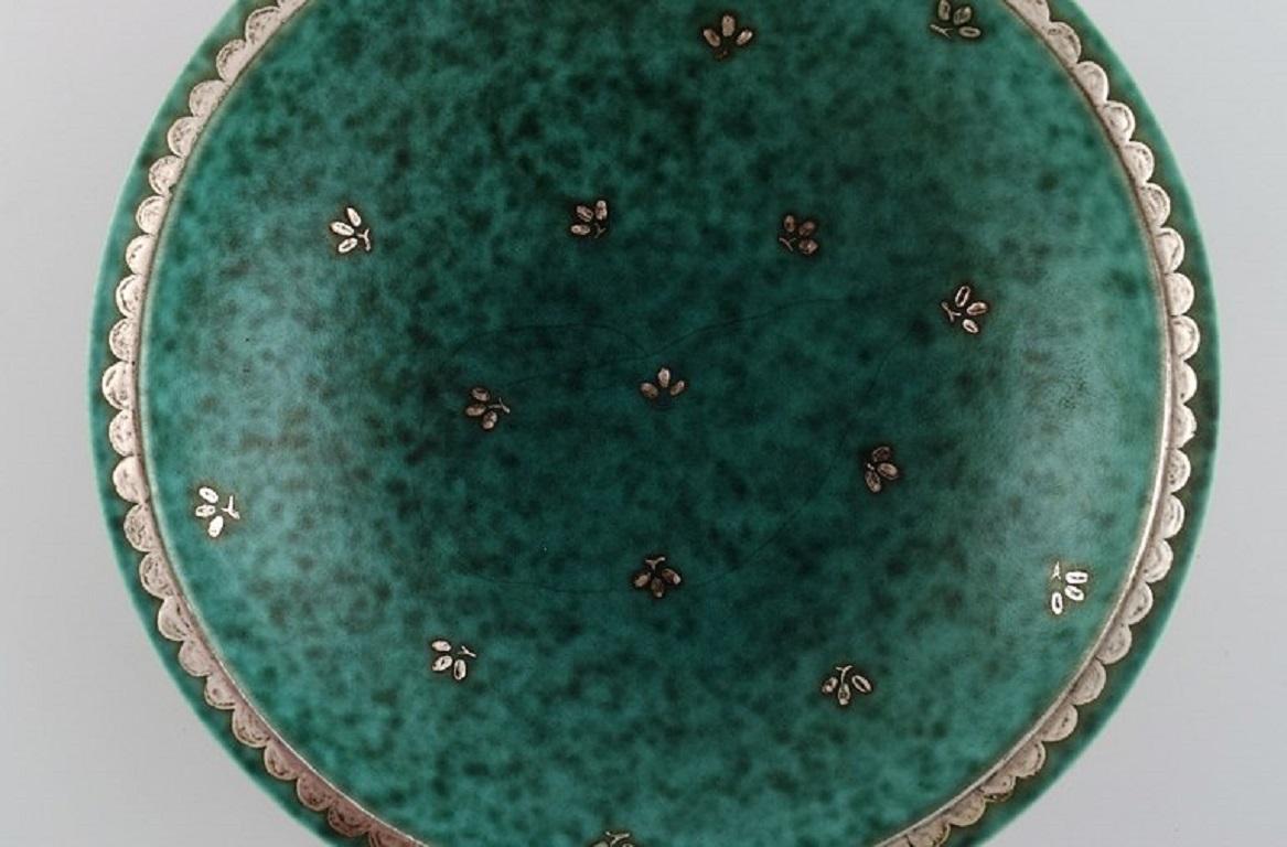 Wilhelm Kåge (1889-1960) for Gustavsberg. 
Argenta Art Deco bowl in glazed ceramics. Beautiful glaze in shades of green with silver inlay in the form of leaves. 
Mid-20th century.
Measures: 18.5 x 5.5 cm.
In excellent condition.
Stamped.