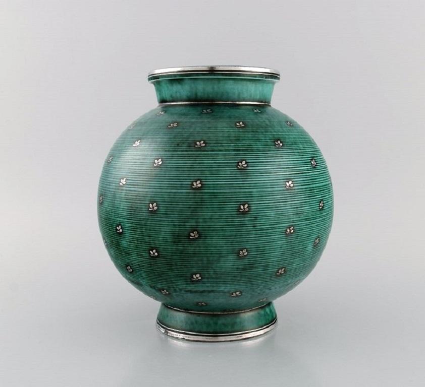 Wilhelm Kåge (1889-1960) for Gustavsberg. 
Round Argenta Art Deco vase in glazed ceramics. Beautiful glaze in shades of green with silver inlays in the form of leaves. 
Mid-20th century.
Measures: 22 x 20 cm.
In excellent condition.
Stamped.