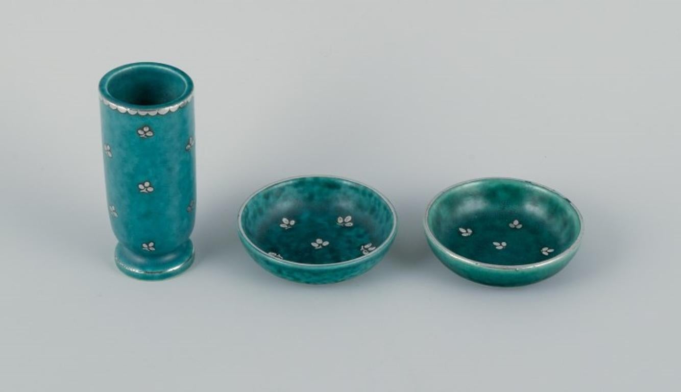 Wilhelm Kåge (1889-1960) for Gustavsberg, Argenta. 
A small vase and two small bowls.
Art Deco, glazed ceramics. Beautiful glaze in shades of green with silver inlays.
Approx. 1940s.
In excellent condition.
Marked.
Vase measures: H 10.0 x D