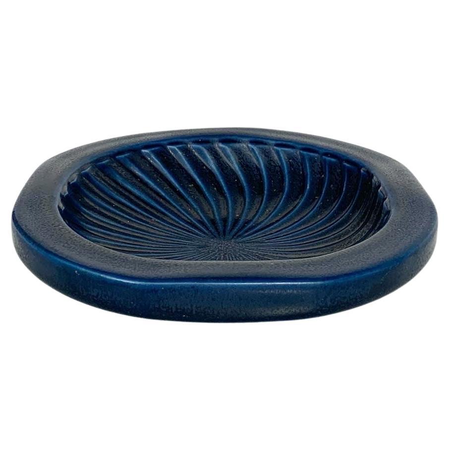 Plato de gres de Wilhelm Kåge para Gustavsberg, Suecia, años 50.

La serie KAPA se produjo en el taller de Kåges en Gustavsberg, junto con Björn Alskog, Axel Pettersson y Birger Arvidson.

Esmalte azul oscuro, gres pesado, marcado por debajo y