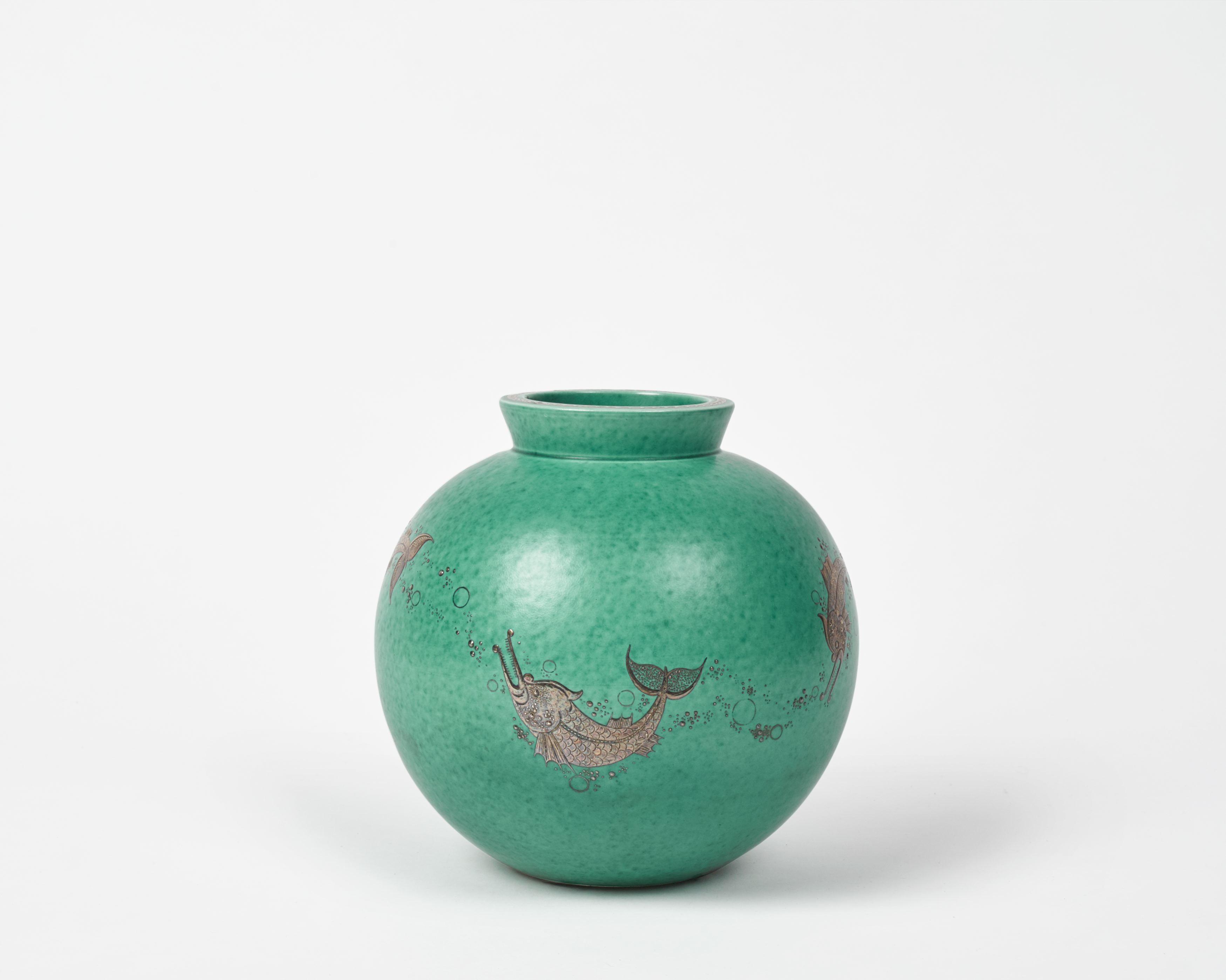 This beautiful piece is part of the artist's Argenta Series, produced for the Gustavsberg Factory, which first won him major success. The series includes everything from ashtrays to 60 kg urns-- primarily in a green glaze with silver
