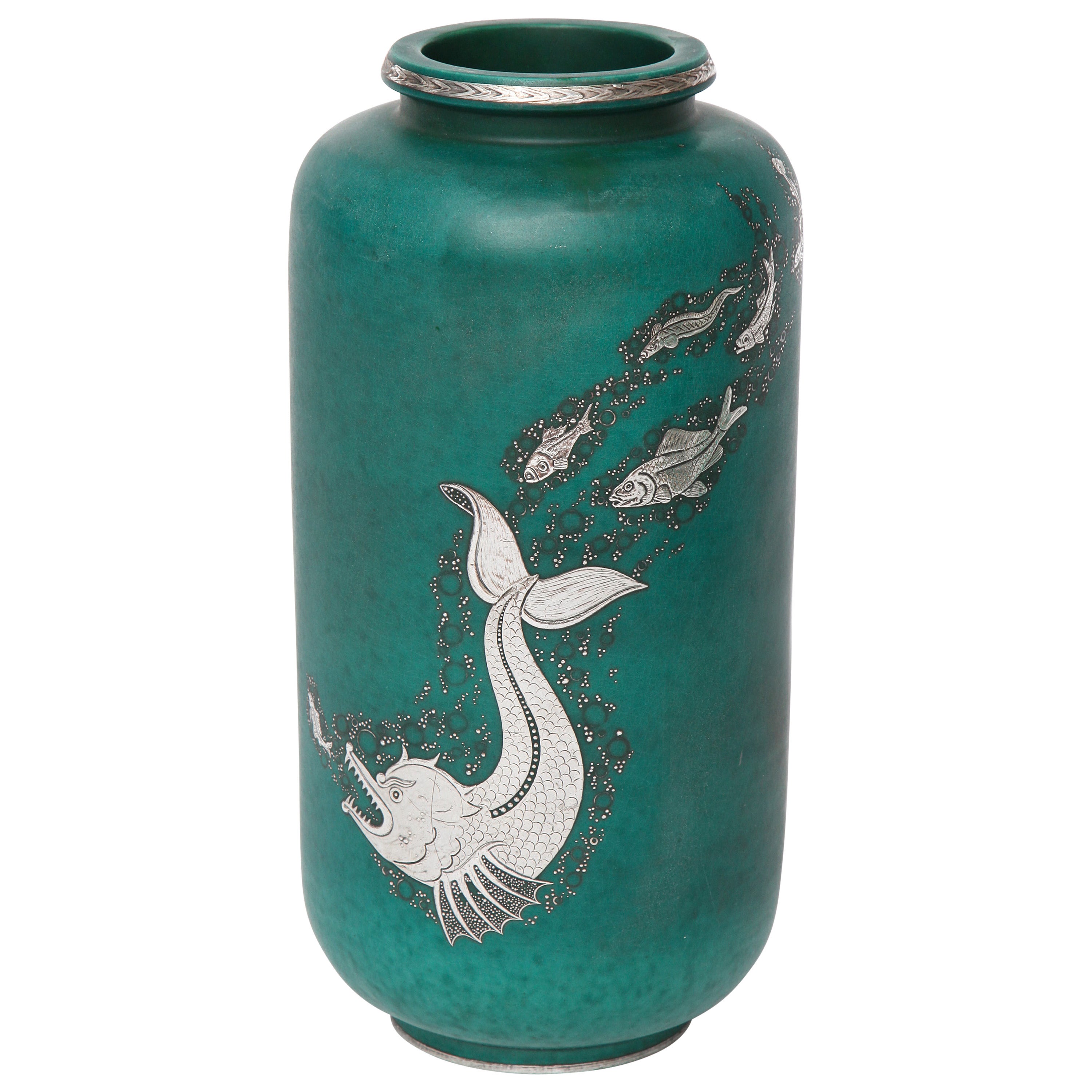 This beautiful piece is part of the artist's Argenta Series, which he produced for the Gustavsberg Factory in 1917, and which first won him major success. The series includes everything from ashtrays to 60 kg urns--primarily in a green glaze with