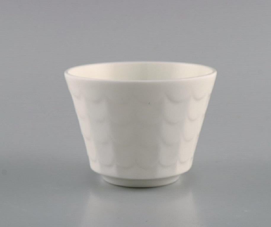 Wilhelm Kåge para Gustavsberg. Ocho macetas de porcelana esmaltada blanca. 
Diseño sueco, década de 1960.
Medidas: 8 x 6 cm.
En excelente estado.
Sellado.