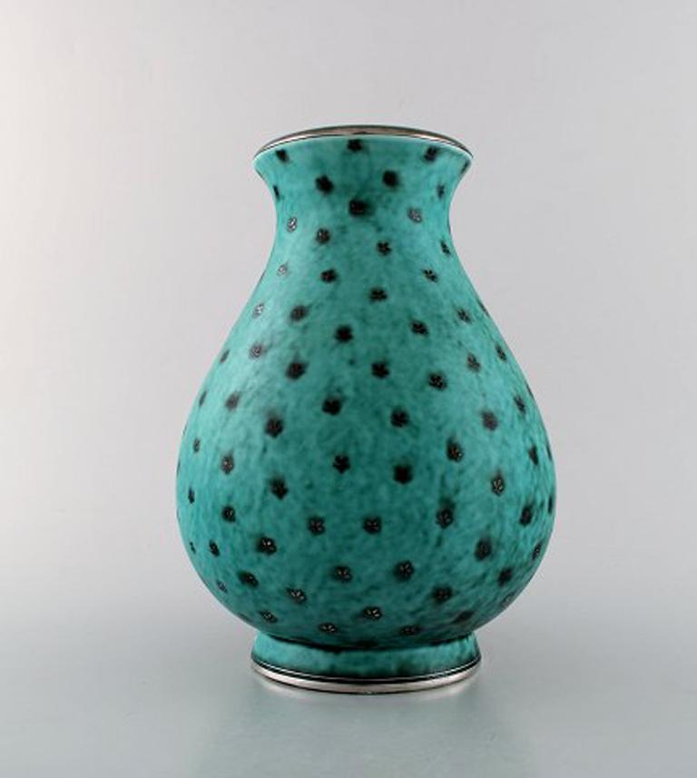 Wilhelm Kåge for Gustavsberg. Large Argenta vase in ceramic decorated with leaves in silver inlaid. Rare shape, Sweden, 1940s.
Measures: 25 x 19.5 cm.
Stamped: Gustavsberg, Kåge.
In perfect condition.