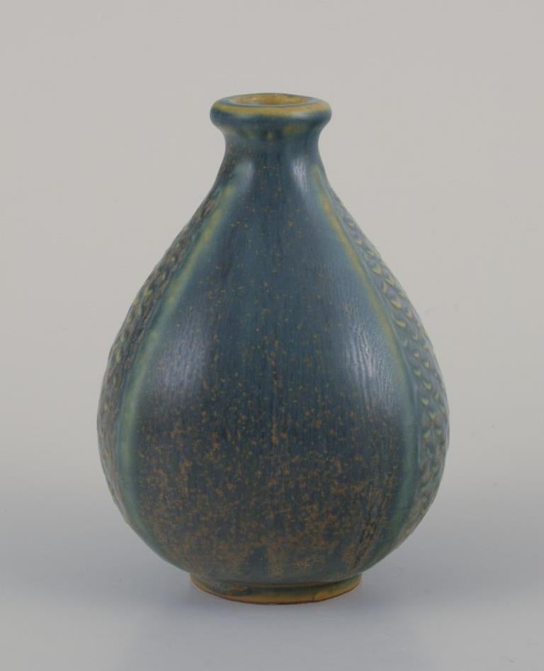 Wilhelm Kåge (1889-1960) per Gustavsberg, Svezia. 
Piccolo vaso di ceramica. Smalto nei toni del blu-verde. Realizzato a mano.
Metà del XX secolo.
Contrassegnato da Kåge Verkstad.
In perfette condizioni.
Dimensioni: H. H. 9,0 cm x P. 6,5