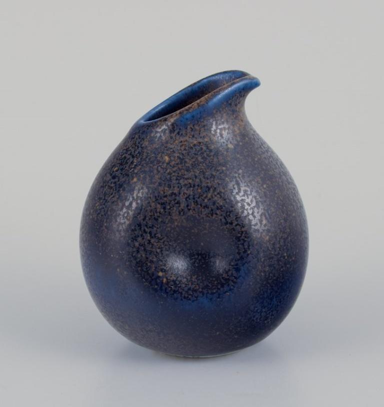 Wilhelm Kåge for Gustavsberg, Sweden.
Small pitcher and salt shaker in ceramic.
Ca. 1940s.
Speckled glaze in blue tones.
Marked.
Perfect condition.
Pitcher: D 7.0 cm x H 8.5 cm.