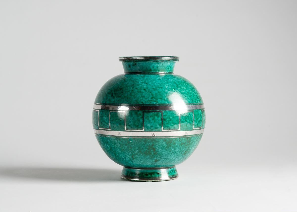 This beautiful piece is part of the artist's Argenta Series, produced for the Gustavsberg Factory, which won him his first major success. The series includes everything from ashtrays to 60 kg urns-- primarily in a green glaze with silver