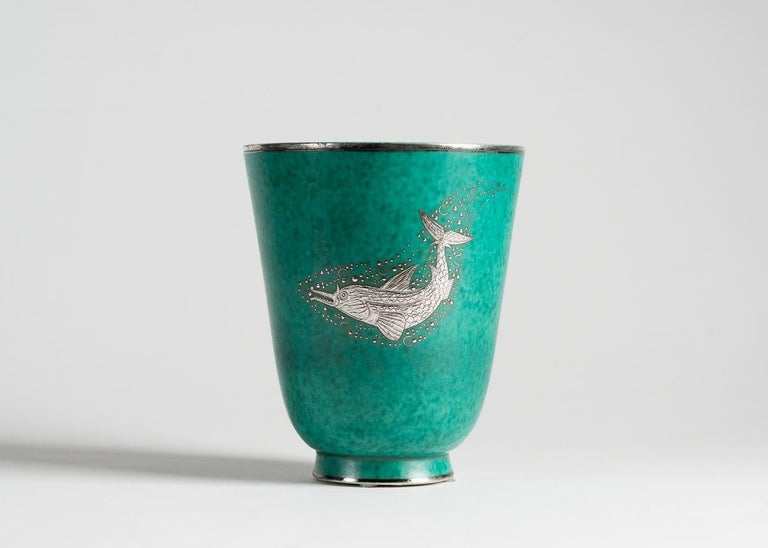 This beautiful piece is part of the artist's Argenta series, produced for the Gustavsberg Factory, which first won him major success. The series includes everything from ashtrays to 60 kg urns, primarily in a green glaze with silver