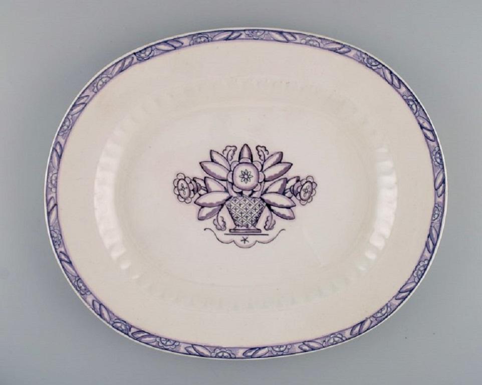 Wilhelm Kåge for Gustavsberg. Vas serving dish and fifteen plates in hand-painted faience. 
1920s / 30s.
Five deep plates, five dinner plates and five lunch plates.
Deep plate measures: 24.5 x 3.5 cm.
Lunch plate diameter: 17.7 cm.
Serving dish