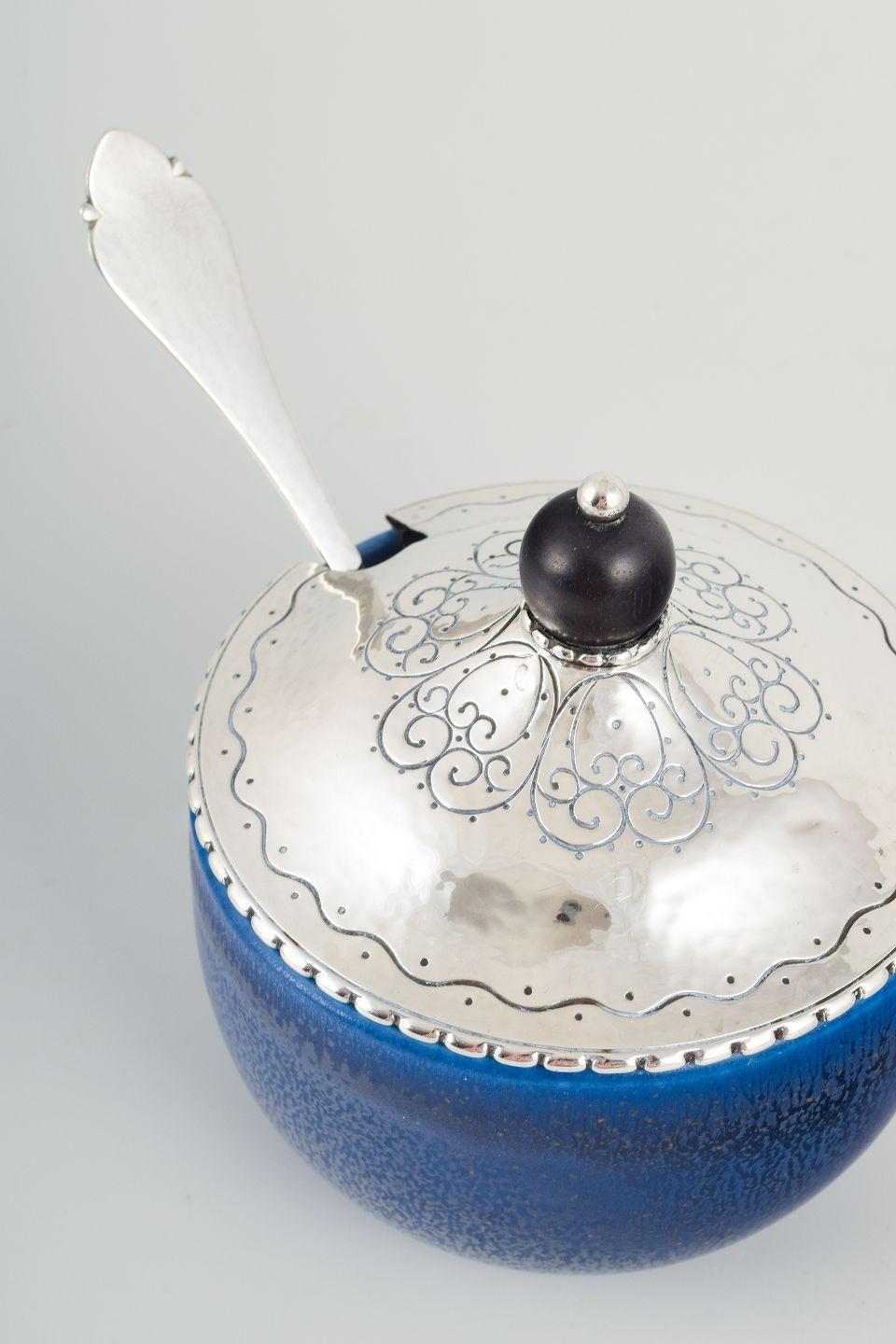PRE-OWNED GOODS ARE EXEMPT FROM IMPORT TARIFFS FOR U.S., UK, AUSTRALIAN & CANADIAN CUSTOMERS.   
THEREFORE, NO IMPORT TARIFFS WILL BE APPLICABLE TO YOUR PURCHASE. 

Wilhelm Kåge (1889–1960), Kåge Verkstad, Gustavsberg.
Jam jar with matching Danish