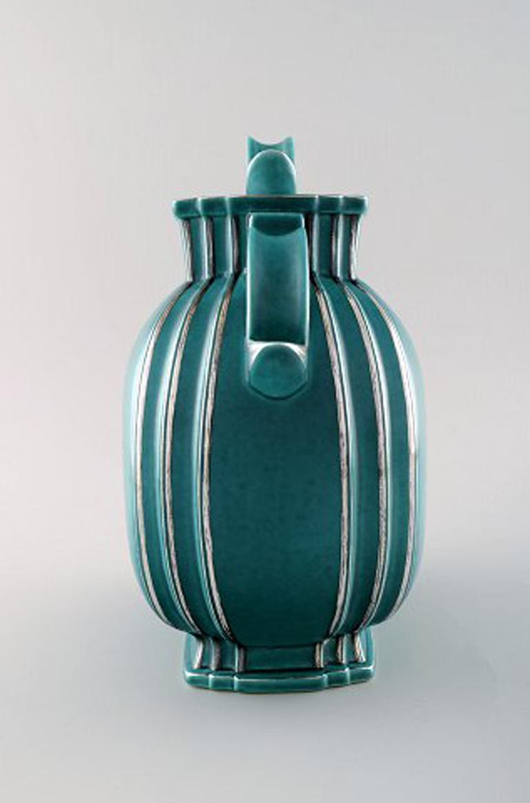 Wilhelm Kåge, Gustavsberg, Argenta Vaso in ceramica Art Deco con coperchio decorato con intarsi in argento.
Svezia anni '40.
Misura 25 x 25 cm.
Marcato Gustavsberg, Kåge.
In perfette condizioni.
Numero di modello: 935.