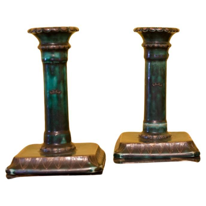 Dark green ceramic candlesticks By Wilhelm kåge Gustavsberg, Sweden in excellent condition quartz colored with silver inlays surround the top of the rim and the foot . 
These are part of the 
