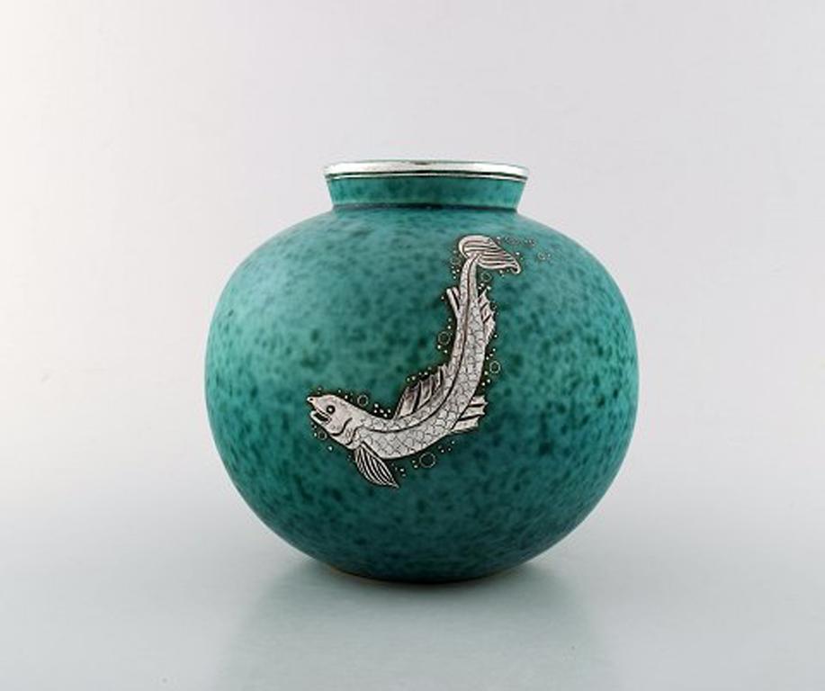 Wilhelm Kåge, Gustavsberg, round handcrafted Art Deco vase in ceramic decorated with fish in silver inlaid.
Sweden 1940's.
Measures: 18.5 x 17 cm.
Stamped Gustavsberg, Kåge.
In perfect condition.