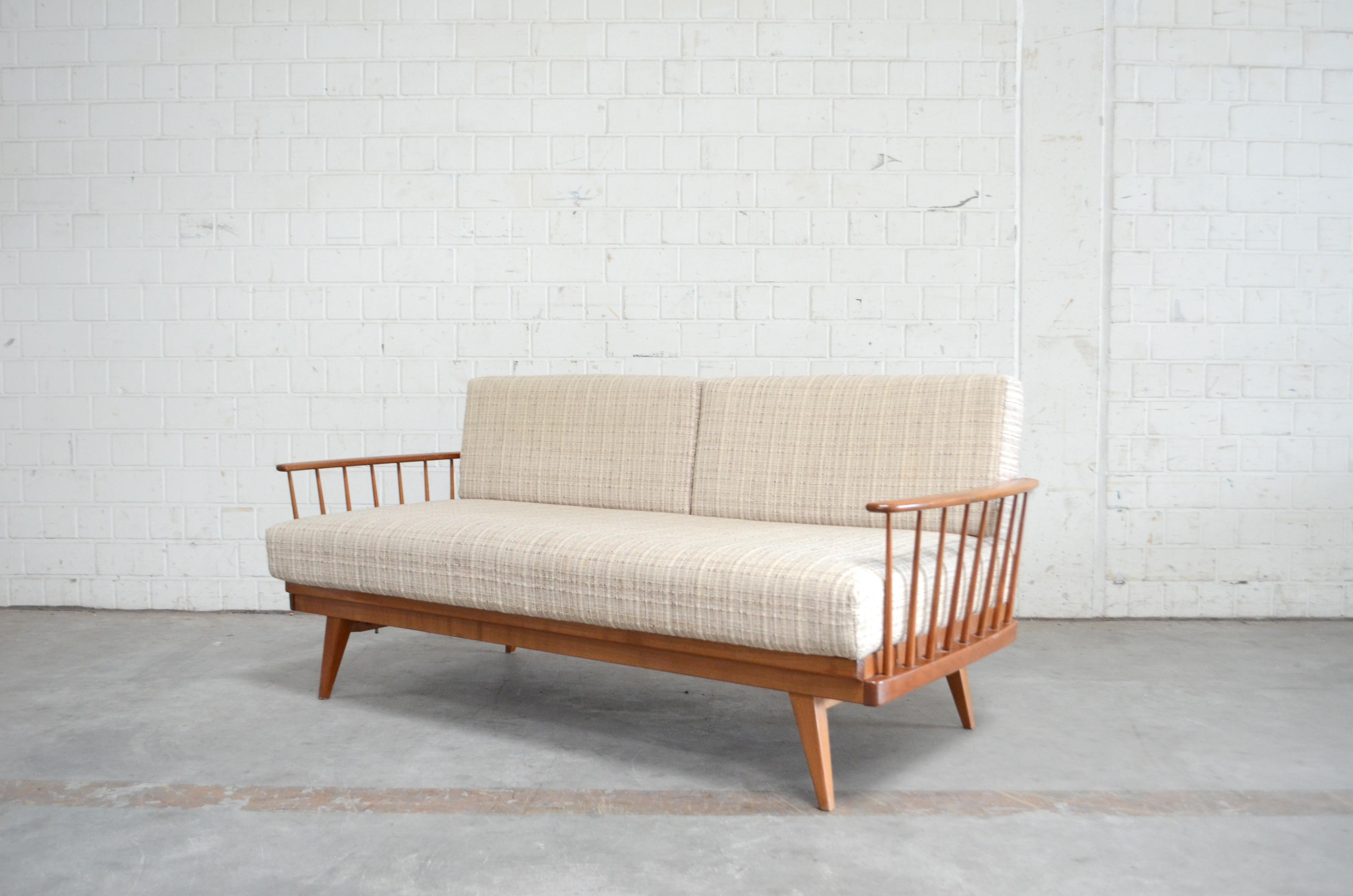 Wilhelm Knoll manufactures this daybed sofa. 
From the Series Antimott.
The frame is made of lacquered cherrywood.
It has a convertible backrest.
You can turn this sofa into a Daybed by pulling out the right armrest.
Wool fabric is original and has