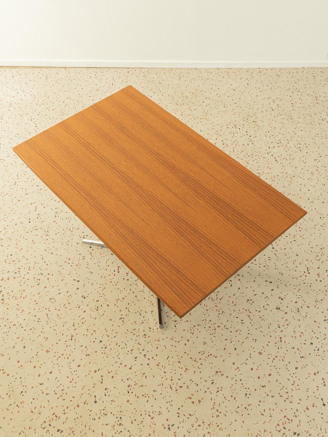 Classic height-adjustable coffee table from the 1960s. Table top in teak veneer and squared steel foot with stainless steel foot cross.

Quality Features:
- very good workmanship
- high-quality materials
- Made in Germany, manufacturer: Wilhelm