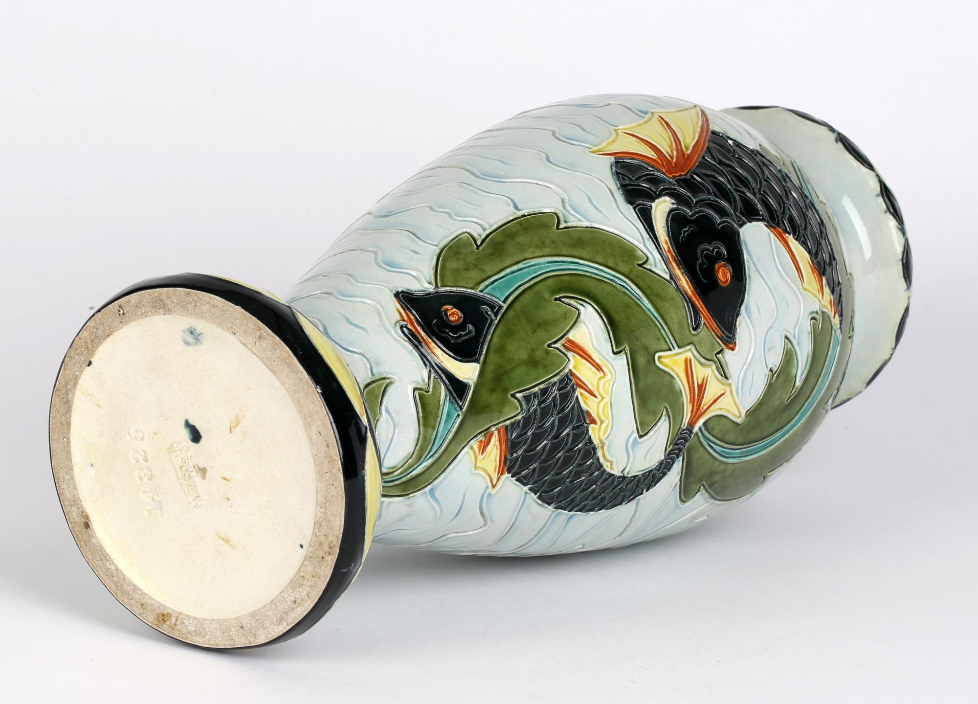 A large and unusual Austrian majolica art pottery vase decorated with fish swimming amidst seaweed by Wilhelm Schiller & Sohn and dating from around 1900. The tall lightly potted earthenware vase stands on a rounded domed base with a tall bulbous