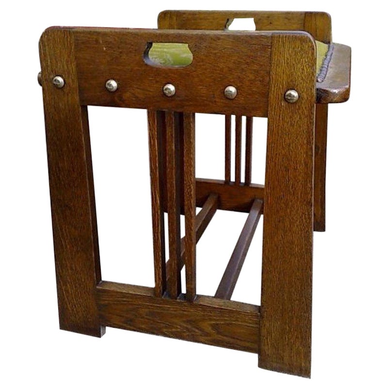 Wilhelm Schmidt and made by Prag-Rudniker, in Vienna. A Vienna Secessionist Arts and Crafts oak piano stool. Tulip-style cut-outs to the topsides and curved seats, three vertical slats to each side, uniting the lower side stretchers to the lower