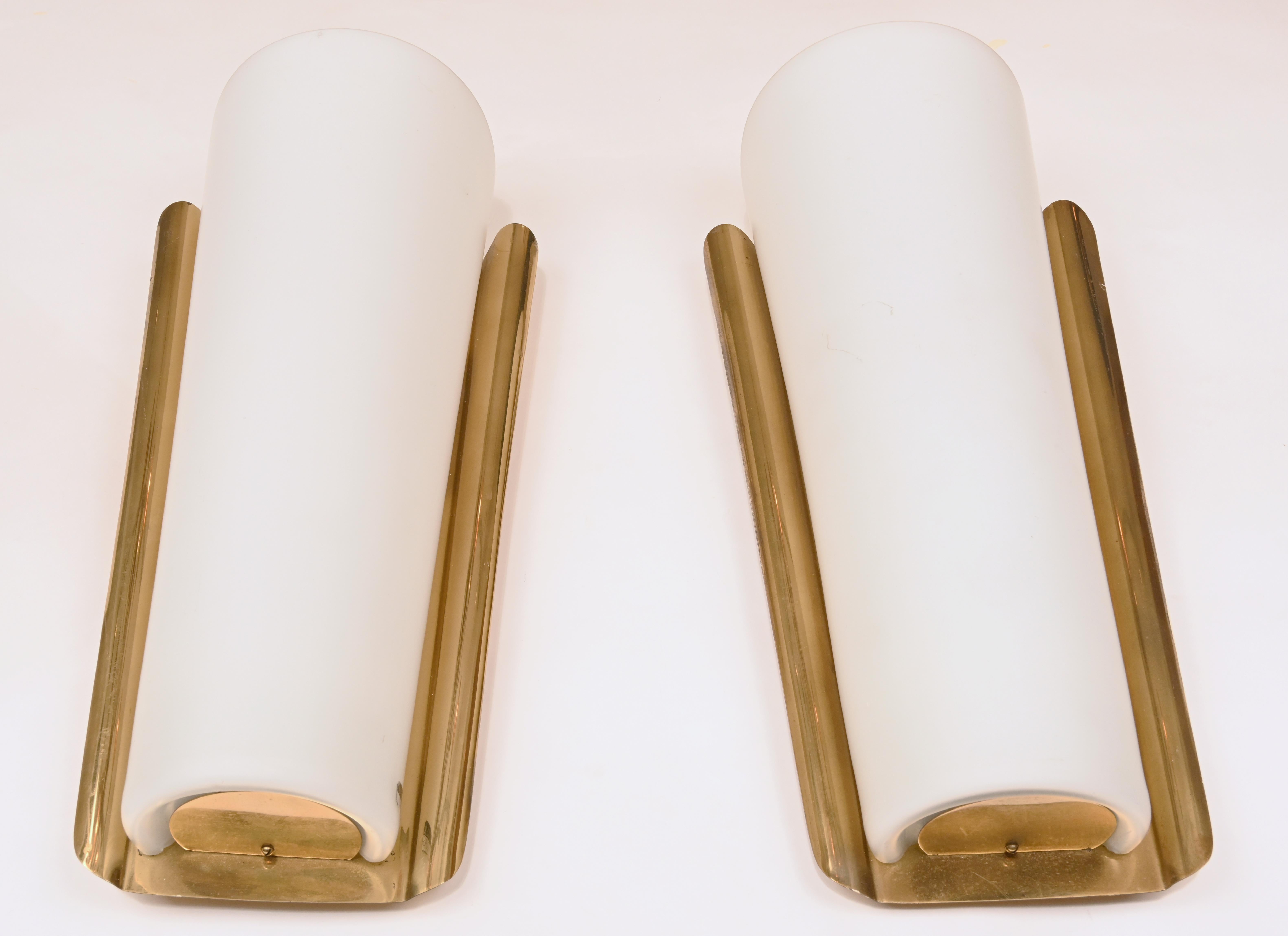 Wilhelm Wagenfeld (1900-1990) for Peill and Putzler, three wall sconces/lamps, opal glass, brass, 1960s, Germany. Set consisting of three wall lights, each with a funnel-shaped brass bracket and an opal glass cover that opens upwards, with two