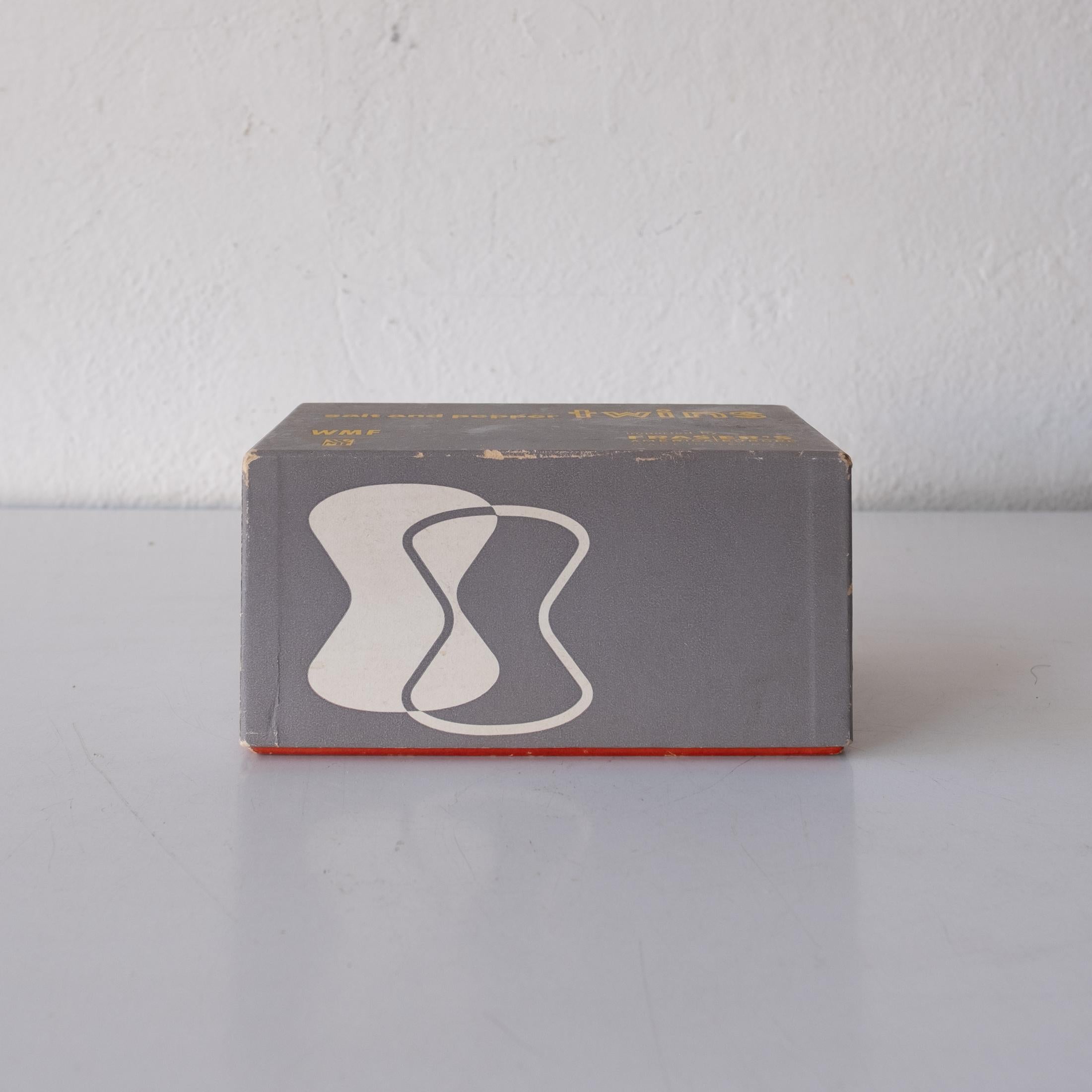 Wilhelm Wagenfeld glass and stainless steel salt and Pepper Shakers, 1952. Produced by WMF of Germany.
Selected for the MoMA Good Design Exhibition and part of their permanent collection.

Unused in the original 1950s box from the prestigious