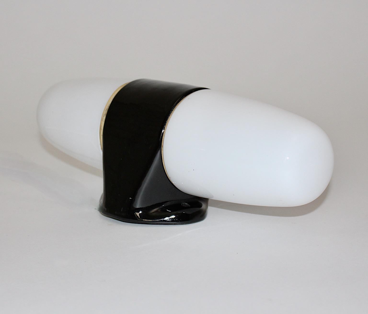 Wilhelm Wagenfeld Mid-Century Modern vintage black and white ceramic glass sconce or wall light, which was designed by Wilhelm Wagenfeld and produced by Linder, Germany circa 1950.
The sconce shows a rare huge size, while the base from black