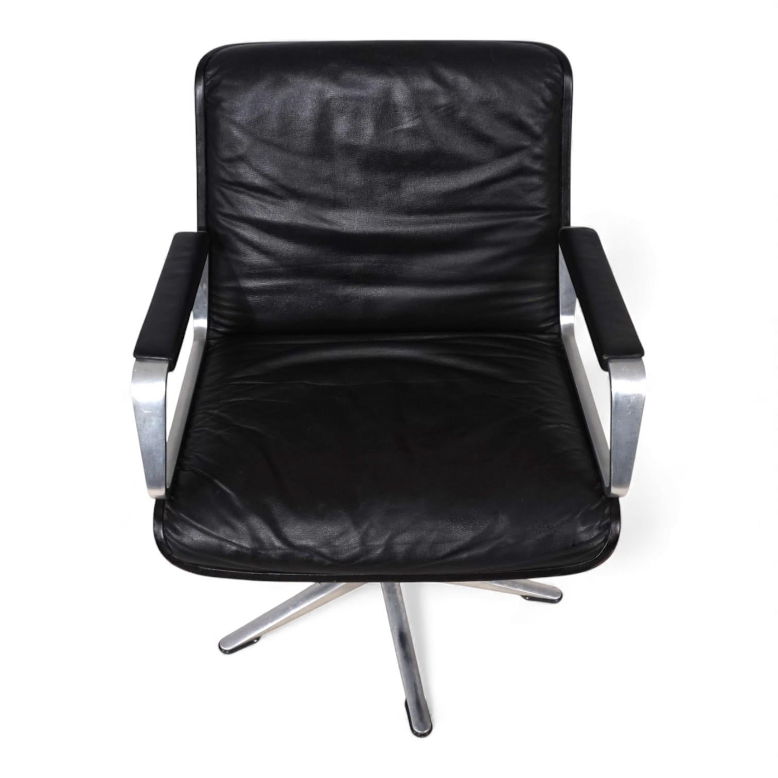 Dieser Ledersessel der frühen Generation von Wilkhahn Delta mit schwarzen Kunststoffschalen und Armlehnen aus gebürstetem Aluminium mit Lederauflagen ist in ausgezeichnetem Zustand. Das Leder ist makellos, und die Kunststoffschalen und