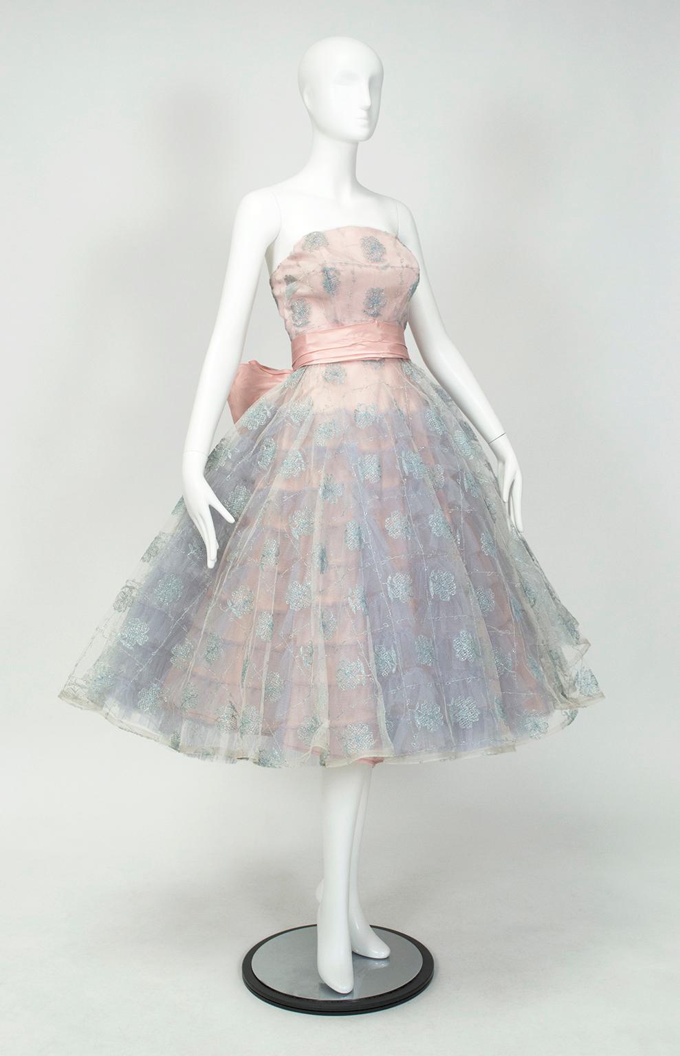 Pure spun-sugar perfection, right down to the cotton candy colors. Visible beneath the silver lattice-embroidered top skirt, the ruffled attached petticoat provides volume enough to span nearly six feet. Not to be outdone, the massive center rear