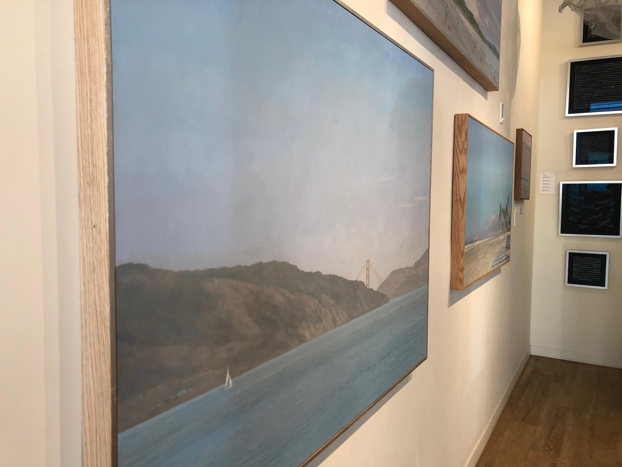 Iconic Golden Gate Bridge peeking from behind rolling California hills at Racoon Strait in San Francisco. Blue sky and water are the painting's focus with a glimpse of a sailing ship on calm water, in this American realist western landscape from