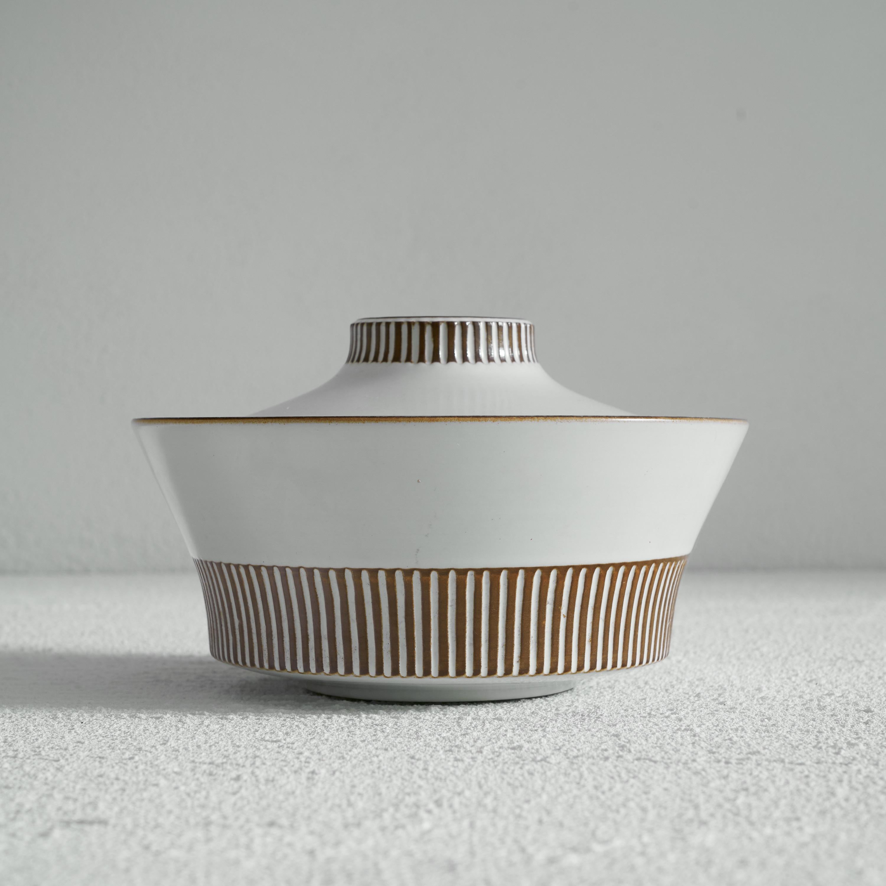 Willem de Vries (1908-1969) Mid-Century Modern 'Cleopatra' Lidded Bowl for Fris Edam. Holland, 1961.

This is very distinct piece of Dutch mid-century modern pottery. Designed by Willem de Vries, who was chief designer at the Fris pottery workshop