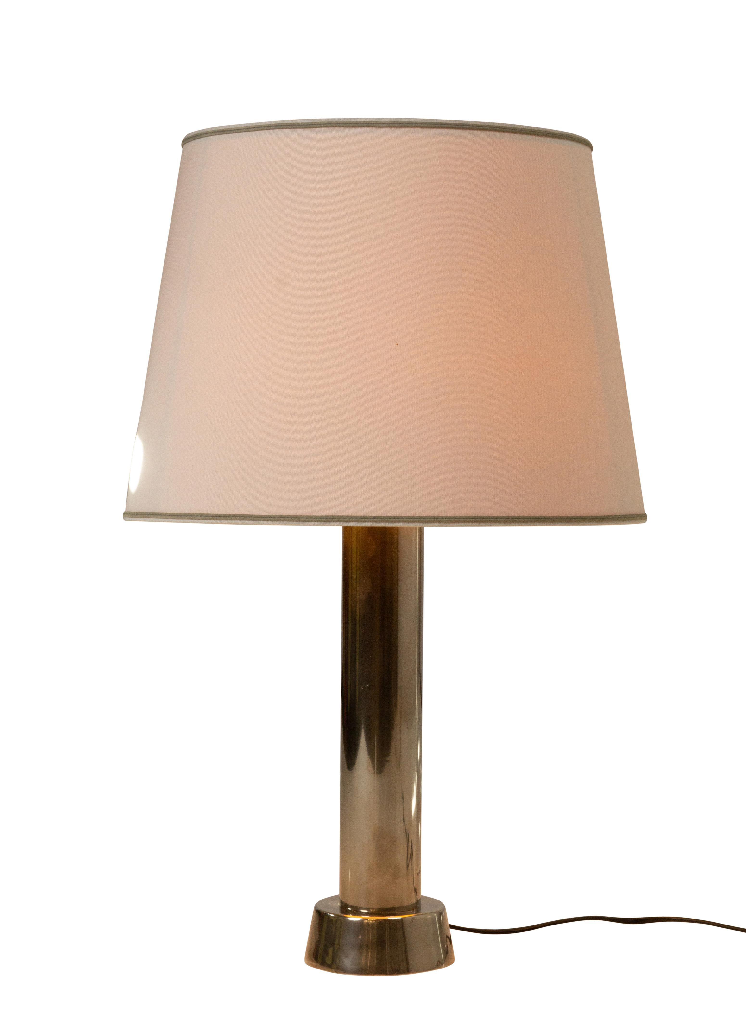 Willem Hagoort table lamp 1970’s.

Chromed cylinder as base, which is quite heavy. The shade is a beige fabric with a artificial diffuser. The artificial diffuser gives a softer light appearance and is a typical modern design detail. Minimal signs