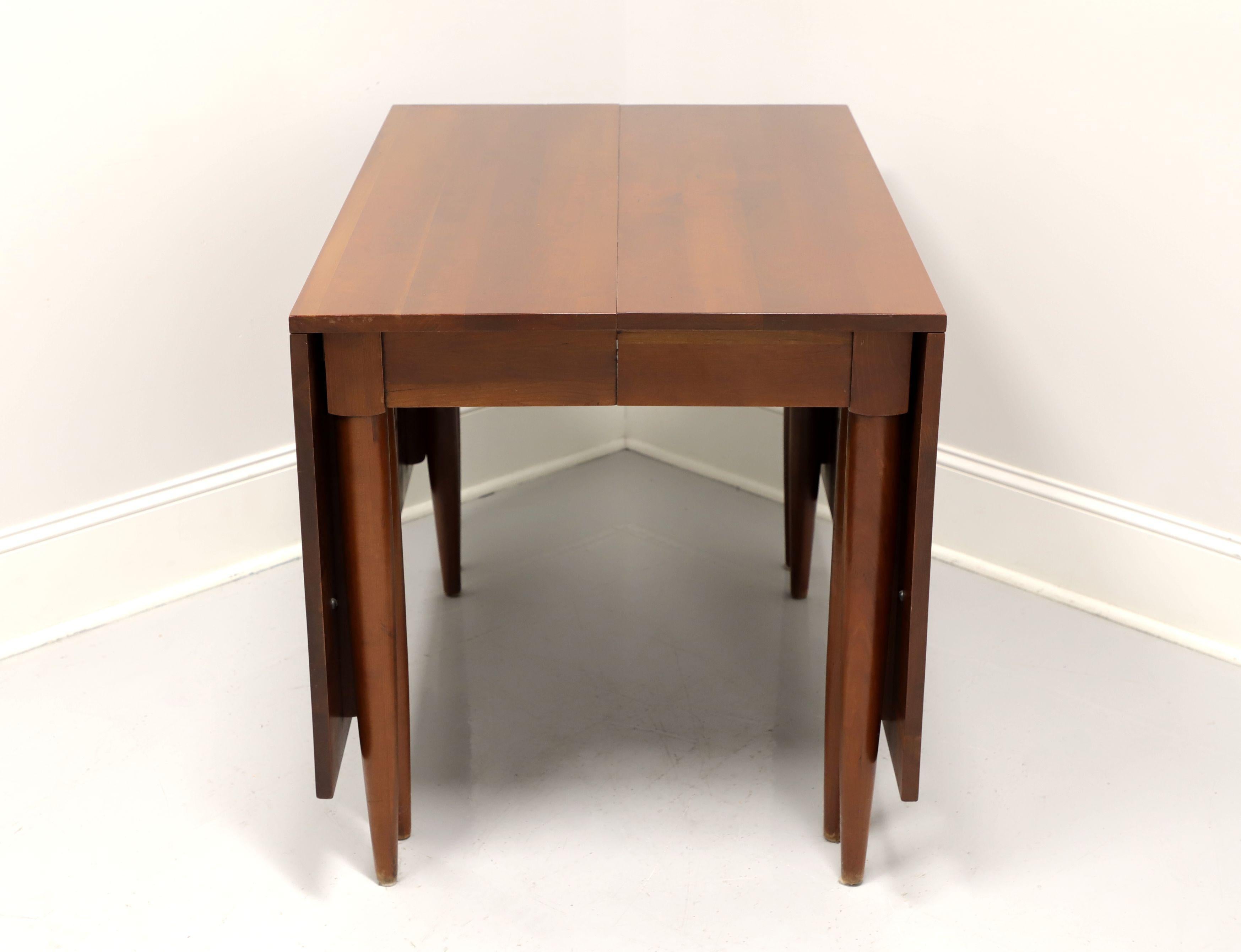 A gateleg drop leaf dining table by Willett Furniture, of Louisville, Kentucky, USA. Solid cherry, a center apron, wood expansion sliders and eight round tapered legs, four being gateleg that swing out to support the drop leaves when raised. Inludes