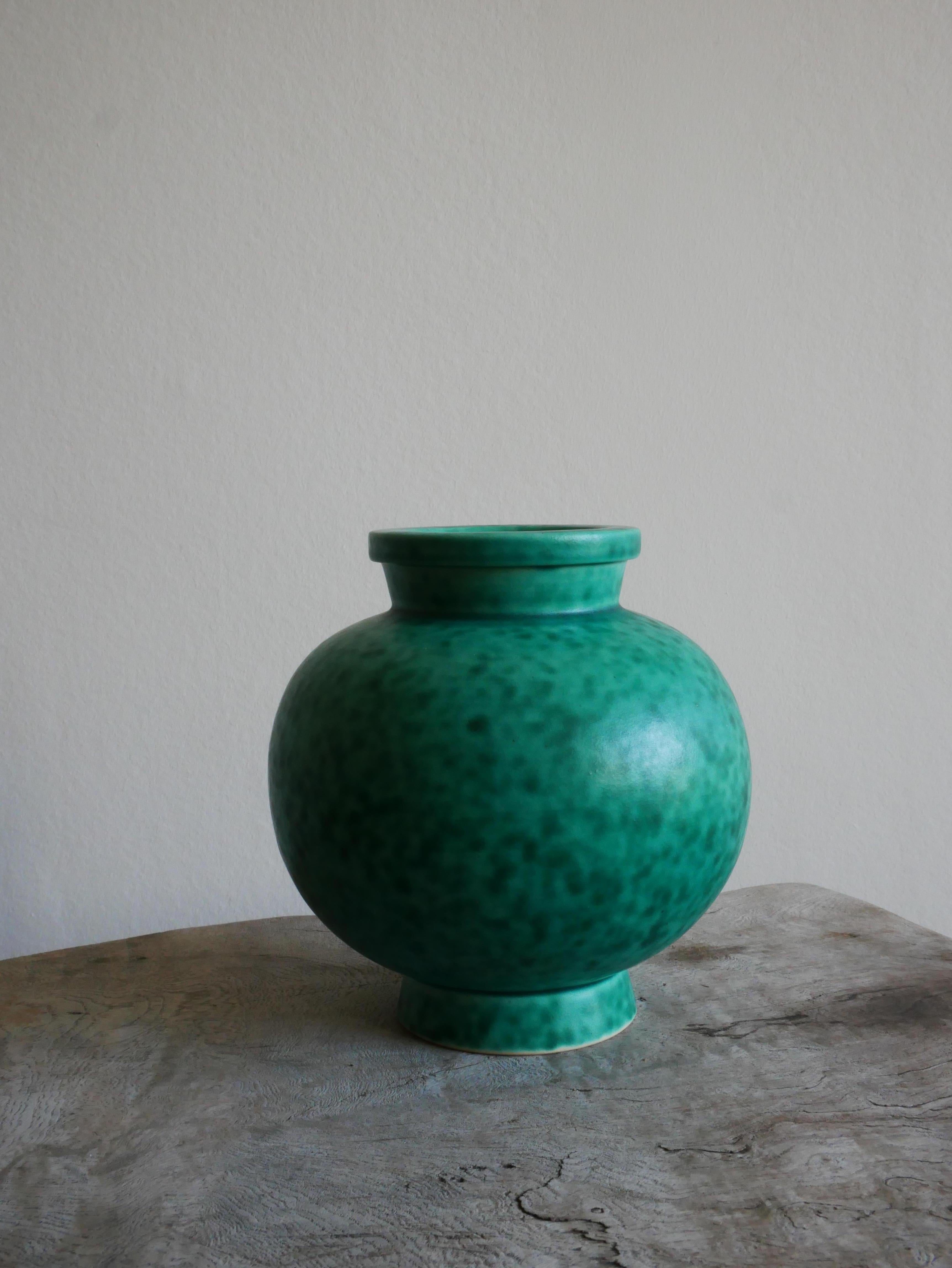 Argenta-Kollektion aus den 1930er Jahren von Wilhelm Kåge für Gustavsberg-
Die ikonische Vase in Argenta mit ihrer grünen Glasur ist eines der bekanntesten Designs von Wilhelm Kåge. Es wurde Ende der 1920er Jahre entworfen und erstmals 1930 auf der