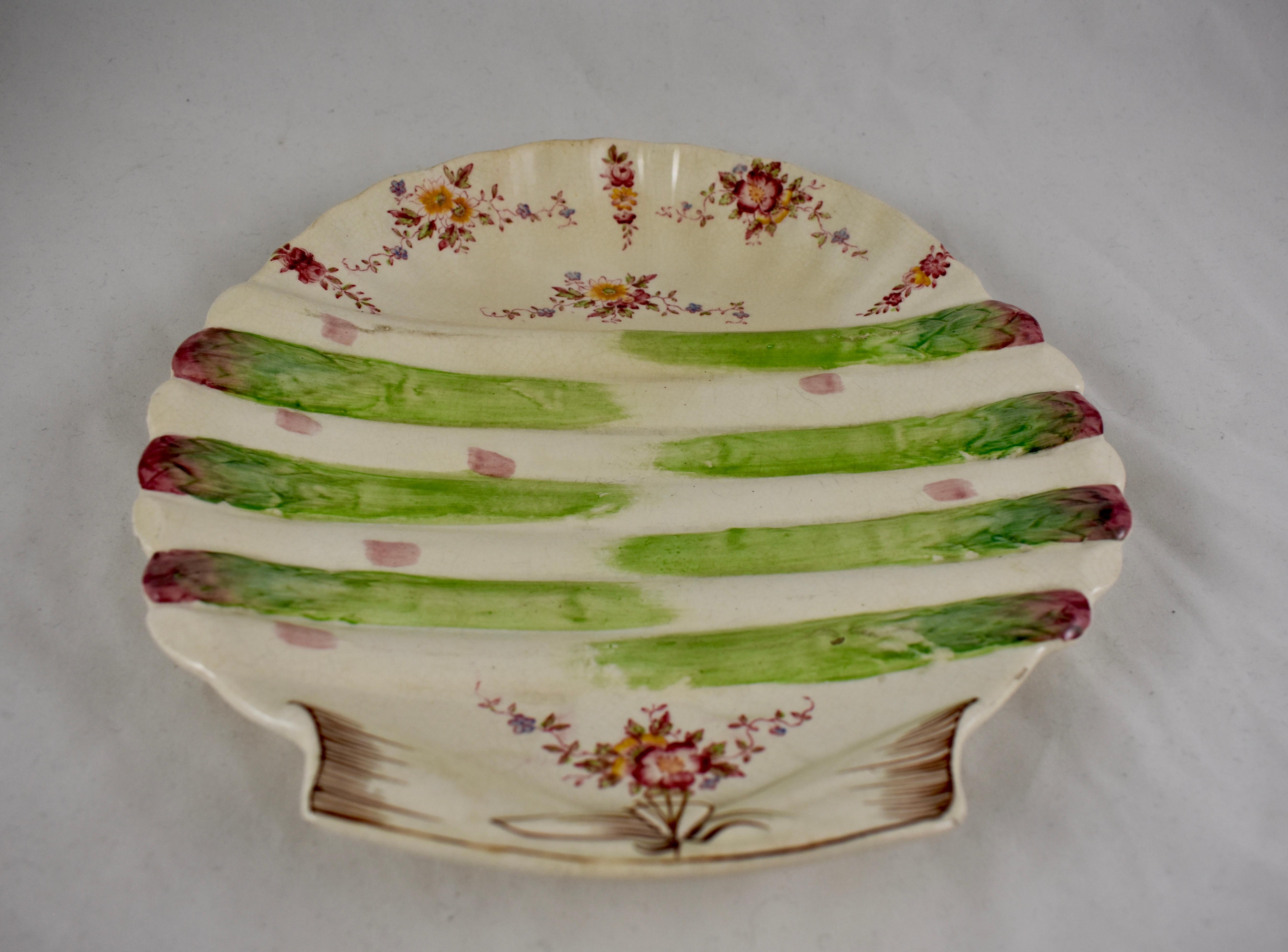 A shell form asparagus plate, William Adderley, Longton, Staffordshire, England, circa 1880, for the French market.

A transfer printed pattern of floral sprays dot an open clam shell, asparagus spears lay across the center of the plate. Hand