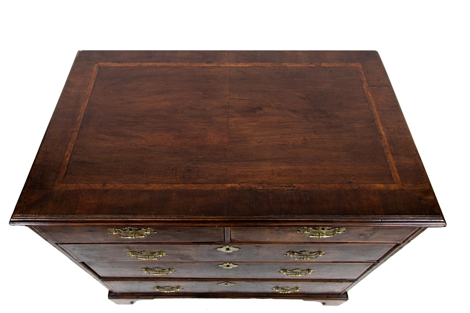 William and Mary five drawer chest, featuring burl walnut veneers and herringbone walnut cross banding. It has engraved brasses.
 