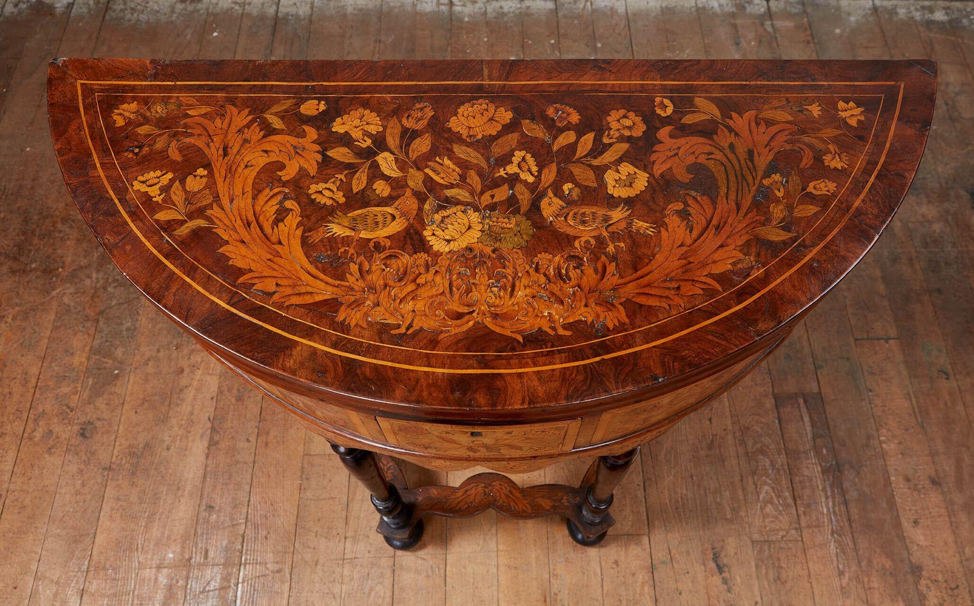 Rare William and Mary marquetry inlaid round card table, the top profusely inlaid with floral deration flanked by two birds over a scrolled acanthus leaf festoon, opening to reveal baize lined playing surface with the aces of clubs and spades, the