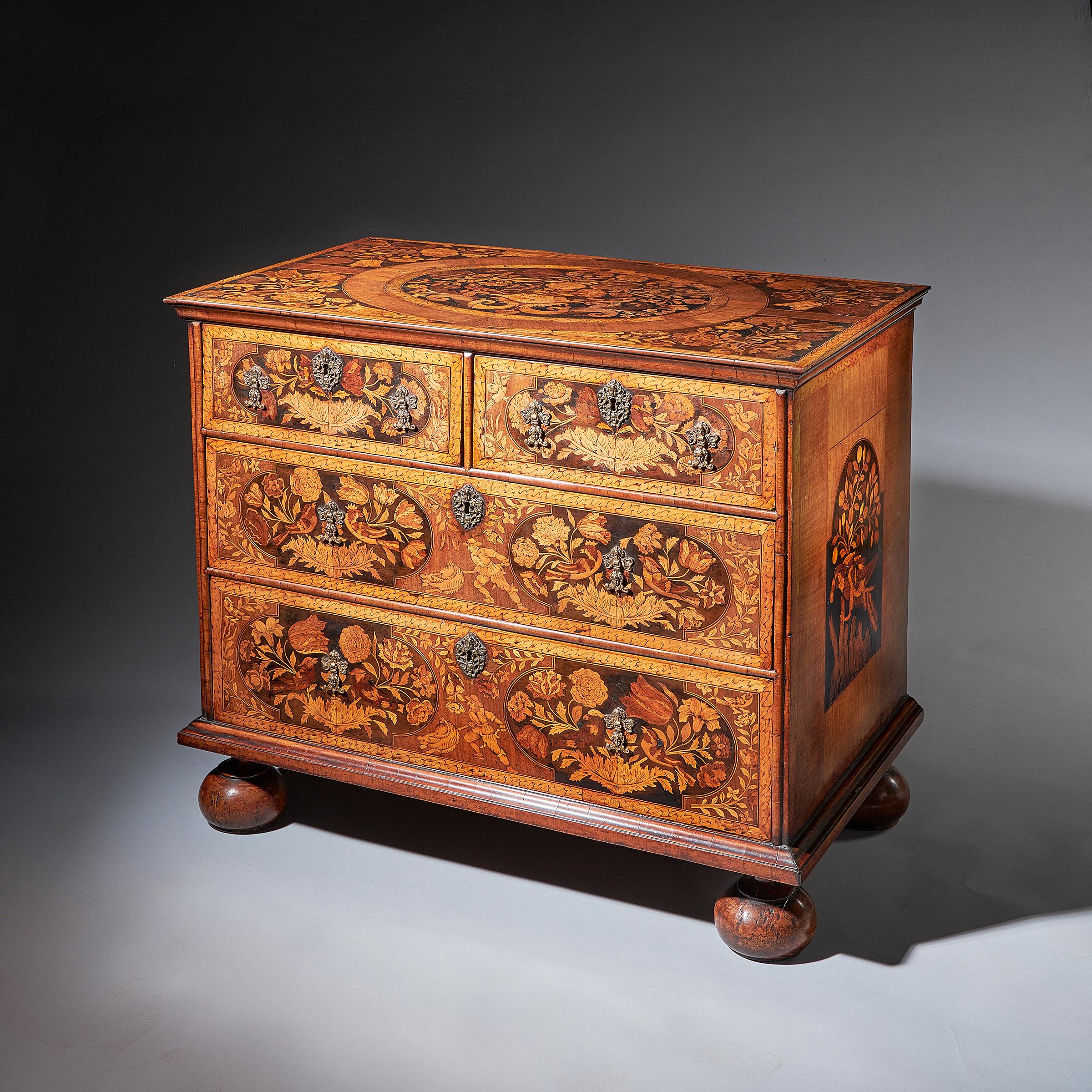 A William and Mary walnut floral marquetry chest, circa 1690.

The rectangular ogee moulded top with central banded oval inlaid with spring flowers, birds and scrolls of acanthus, on ebony ground. The two short and two long graduating drawers are