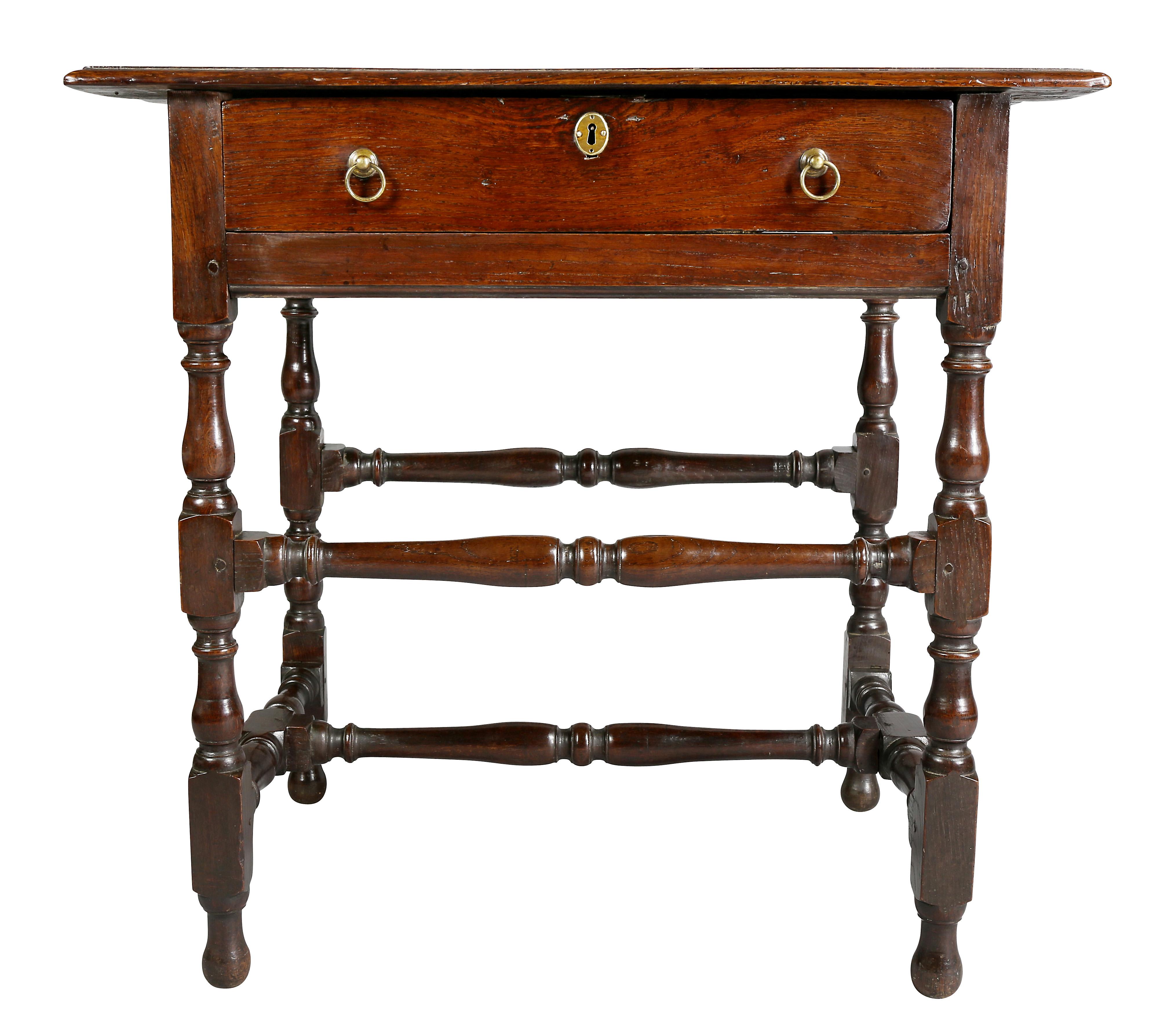 With rectangular top over a single drawer with ring handles, turned legs joined by turned stretchers.