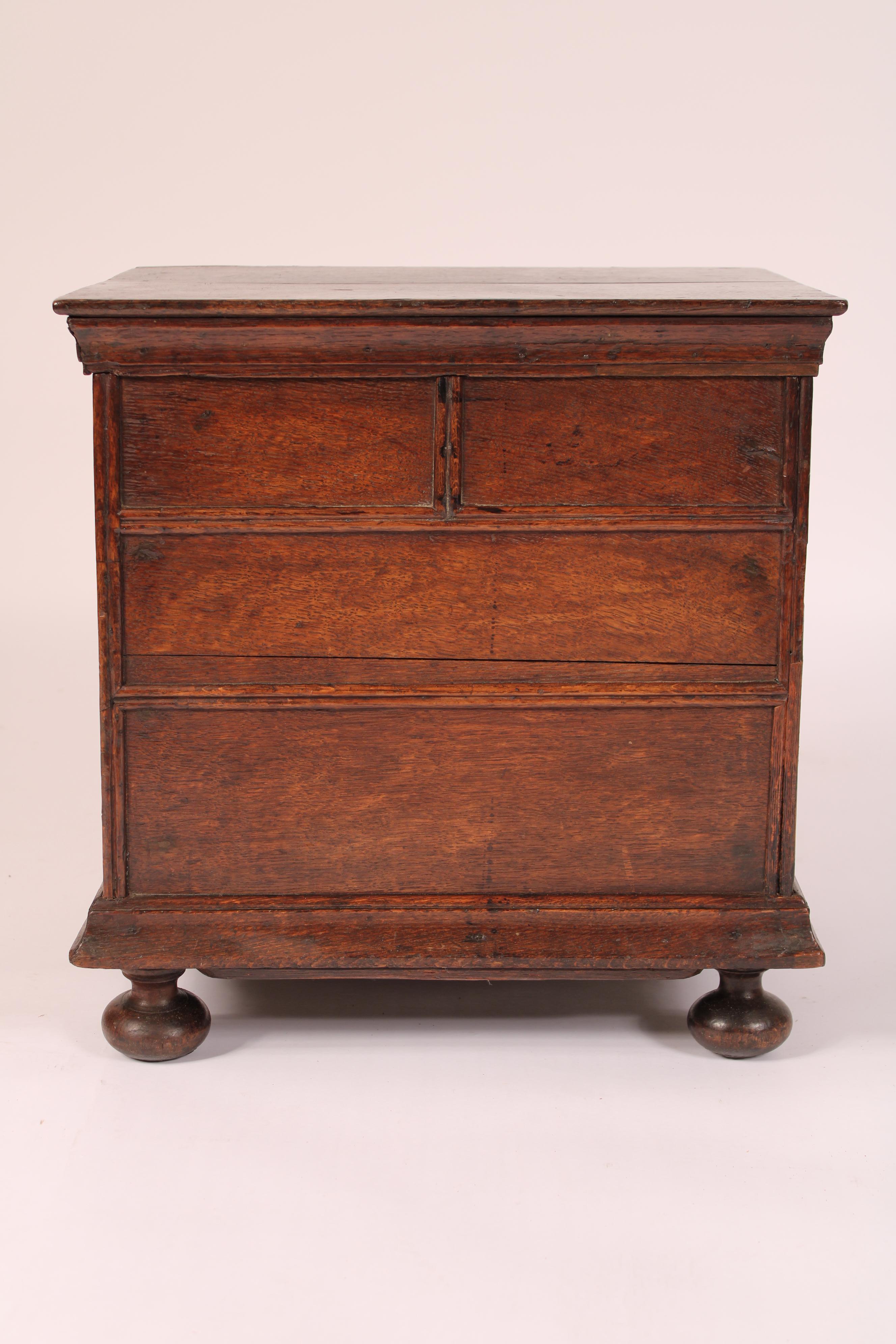 Antique William and Mary style oak trunk, 18th century. With a two board oak top, the front with half round moldings, the sides with carrying handles, the inside with a metal liner, resting on later bun feet. 