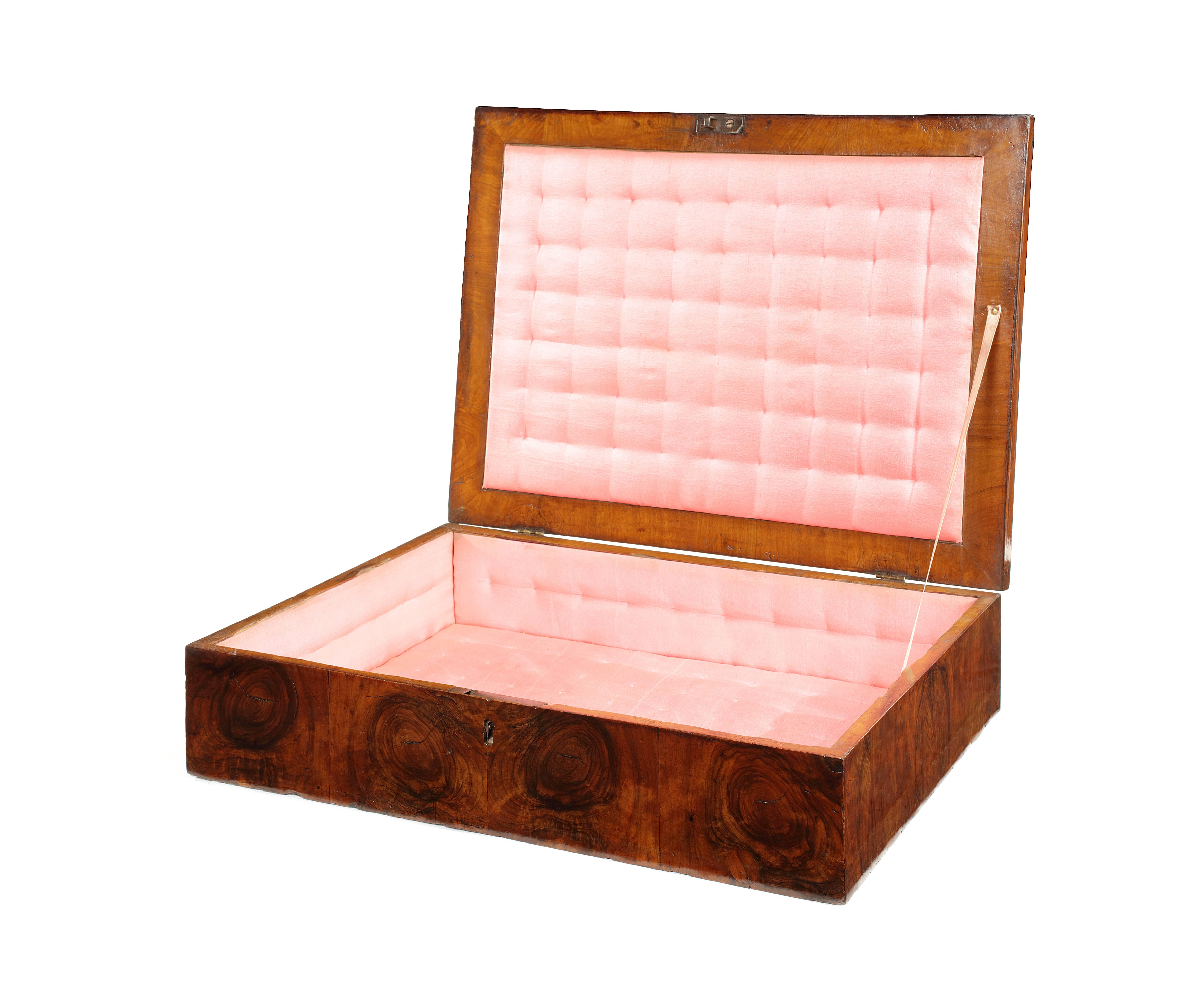 A William and Mary walnut, feather banded and olive oyster veneered dressing box
The rectangular hinged lid with a central oyster veneered oval surrounded by similar shaped panels enclosing a later pink silk lined quilted interior above straight