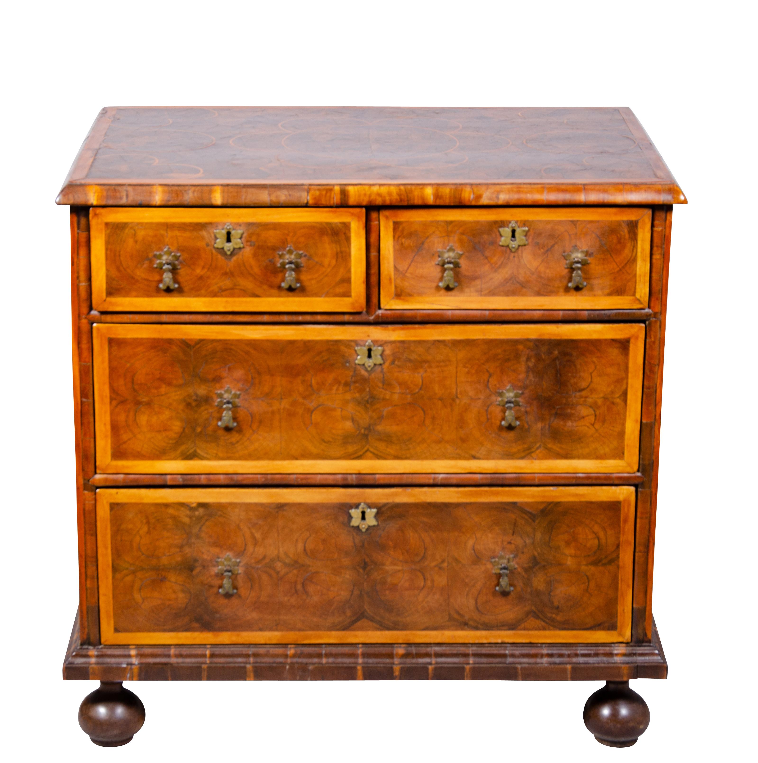 A choice diminutive chest with an oyster veneer top { oyster veneer was highly prized cross sections of tree limbs offering a highly figured design with boxwood stringing to divide the design. with two short drawers over two long drawers all with