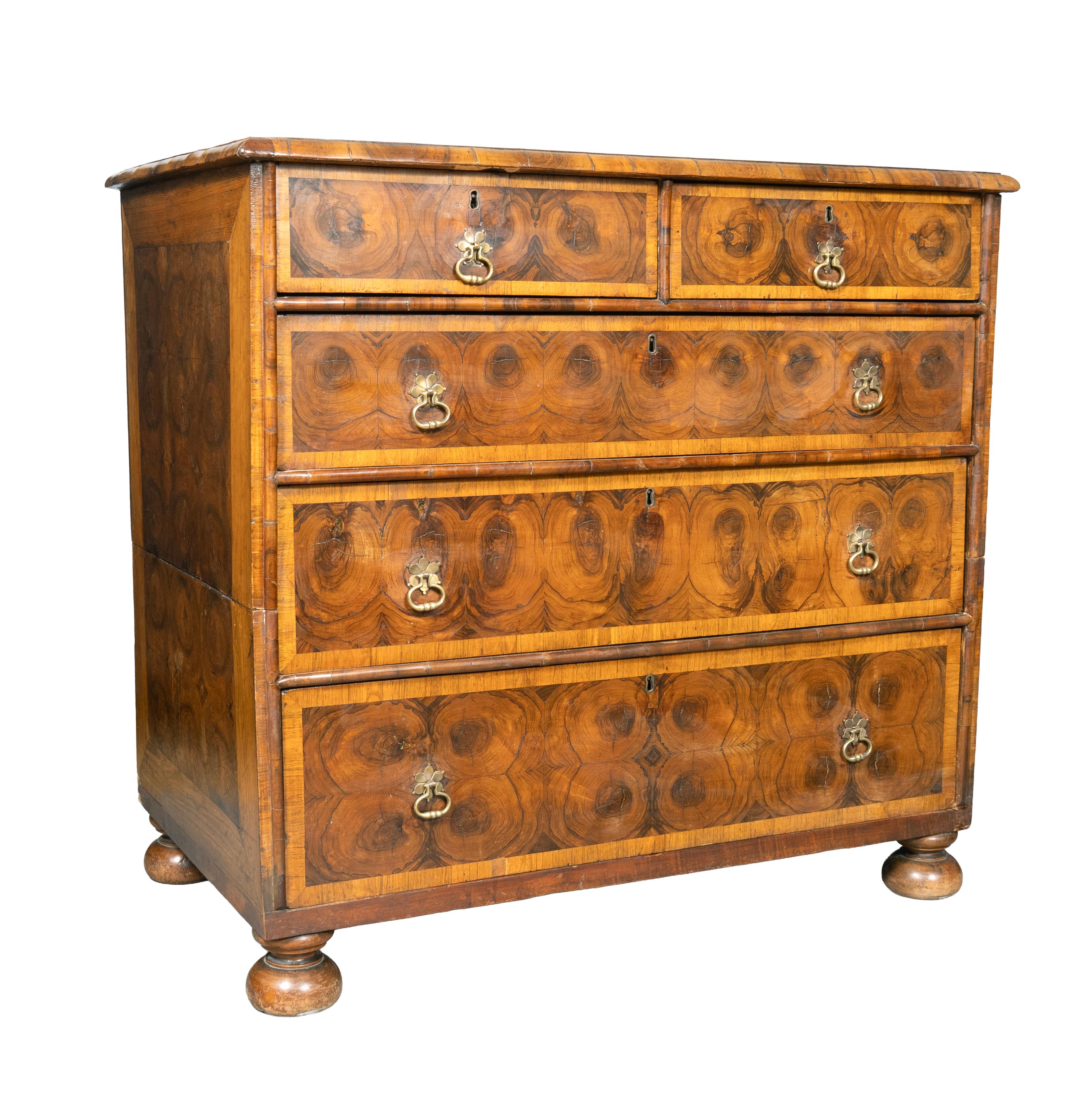 Made in two parts to be able to go up a narrow stairway. The rectangular top with oyster veneer rings and compass rose.With two drawers over three long drawers. Brass ring handles. Bun feet.