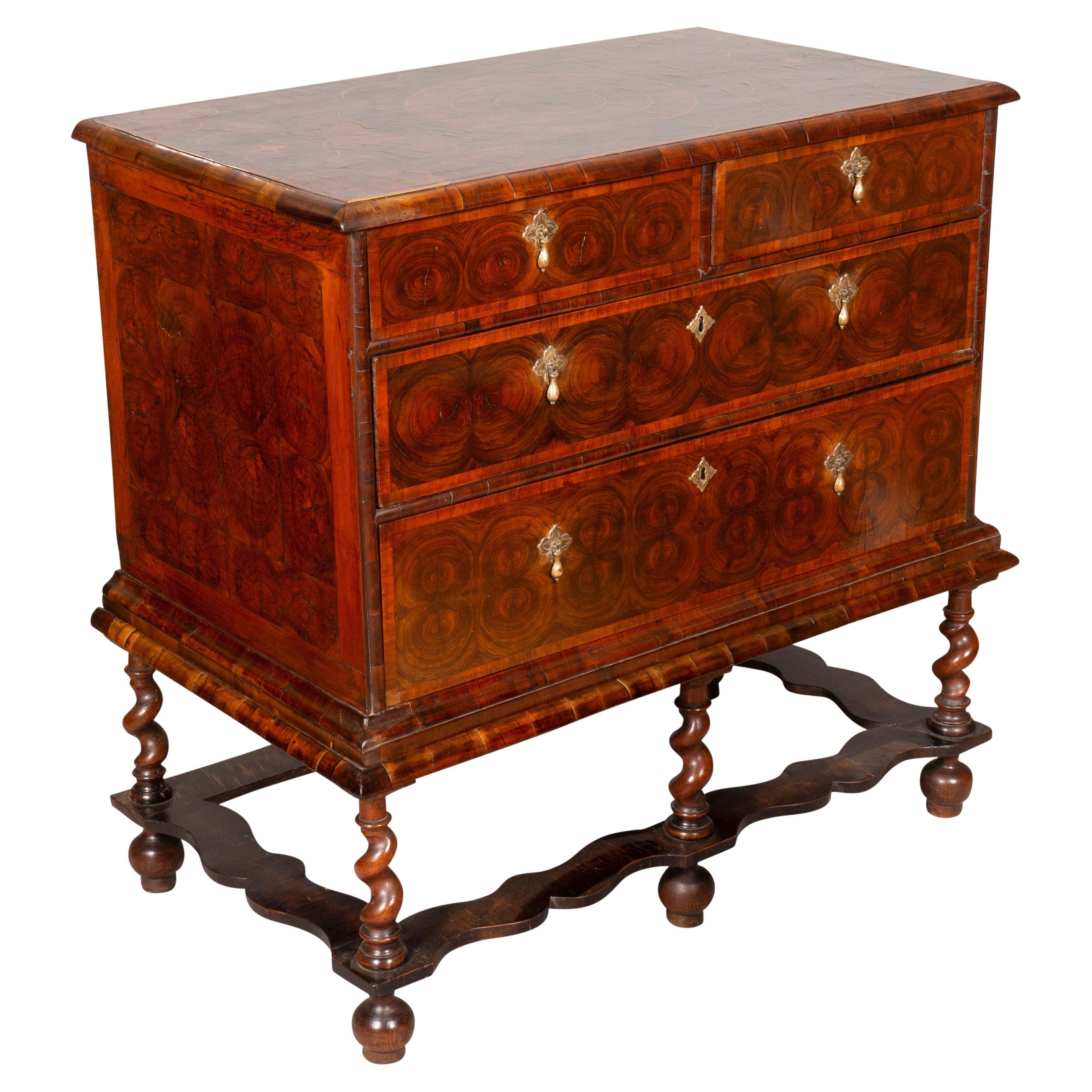 With an elaborately inlaid top with wonderful oyster decoration over two short over two long drawers, raised on a separate barley twist base. With overall oyster veneers. Bun feet likely replaced at some point.