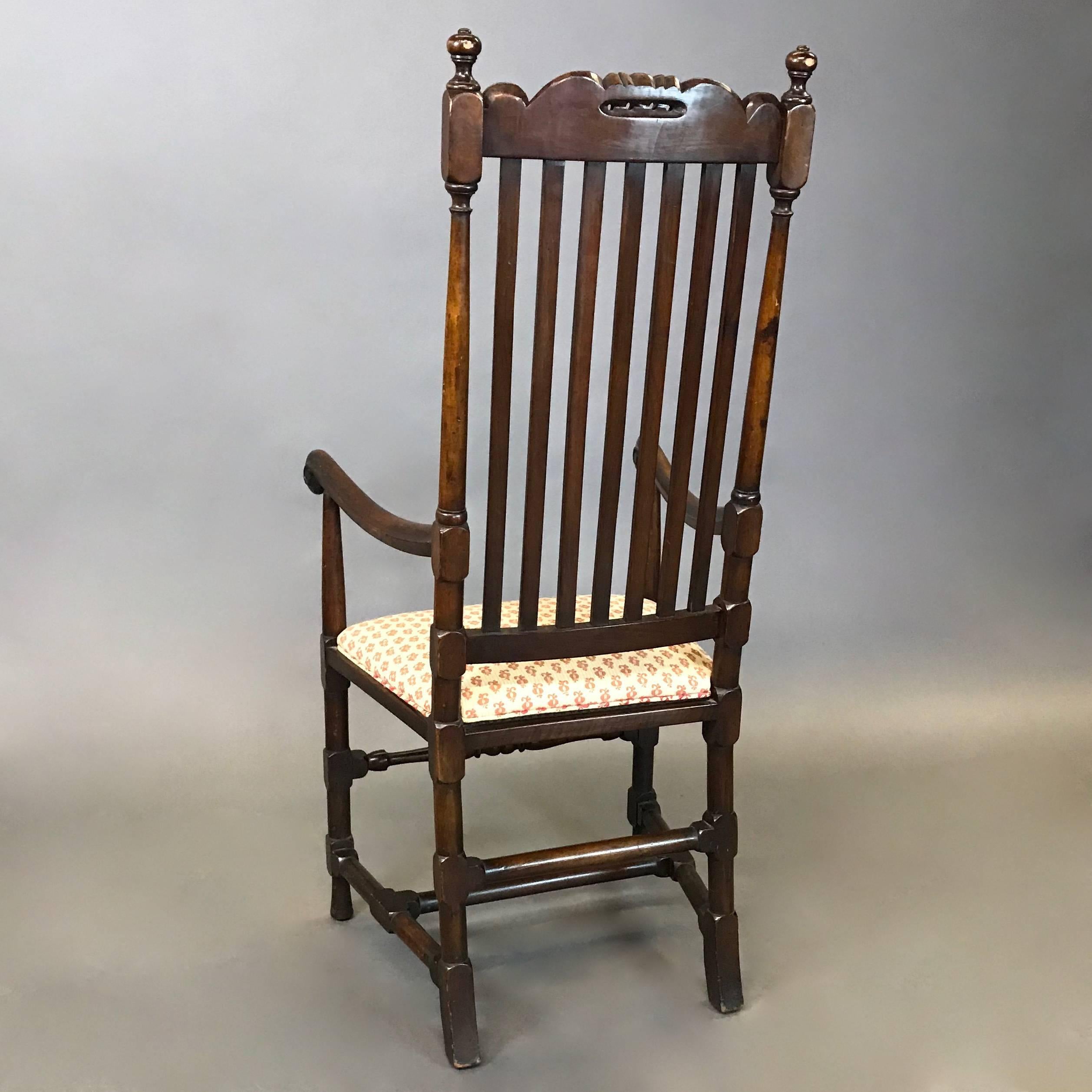 American, late 19th century, William and Mary style, mahogany captain's armchair features a high, slat back with carved crest, baluster and block turned legs, scroll hand-grips and a newly upholstered seat. The seat depth is 14 inches and the arm