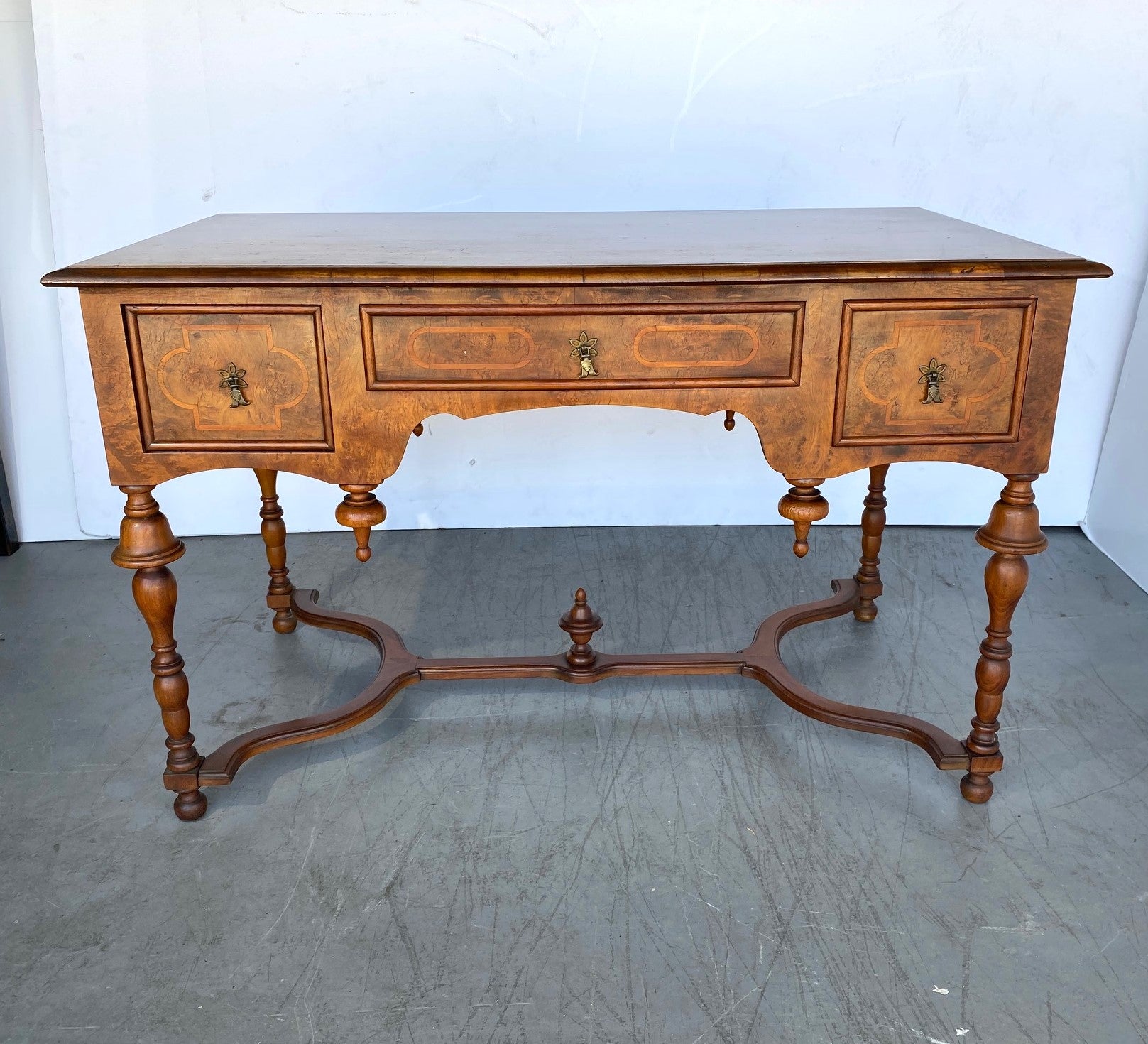 A walnut desk with a burlwood drawer front and on the sides. Willaim and Mary style made by John A Colby.