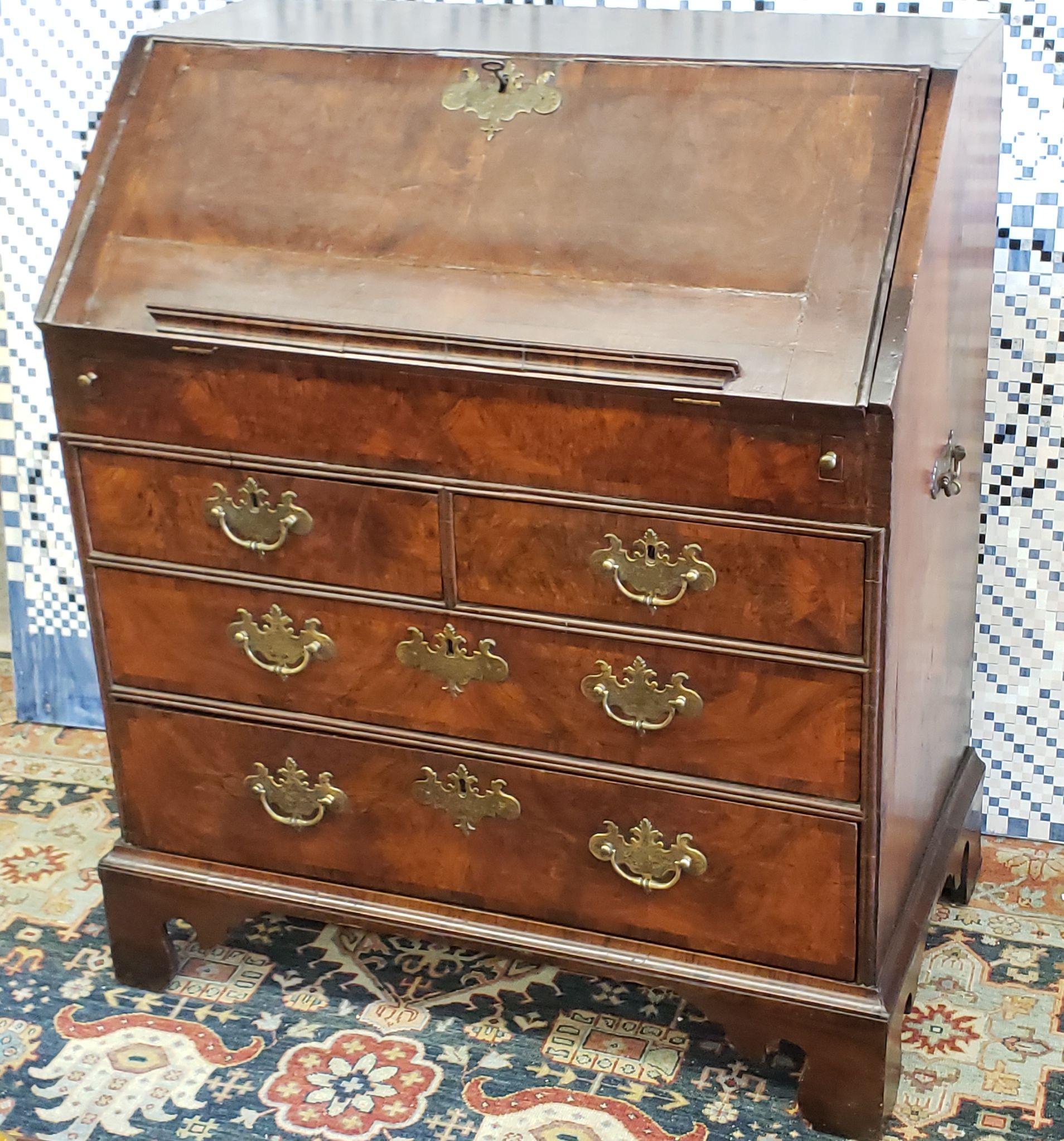 An early 18th century William and Mary Burled walnut veneer desk with book rest and side handles for transport. Pulls were replaced early on as styles changed and are early 18th century nice engraved handmade pulls.
  