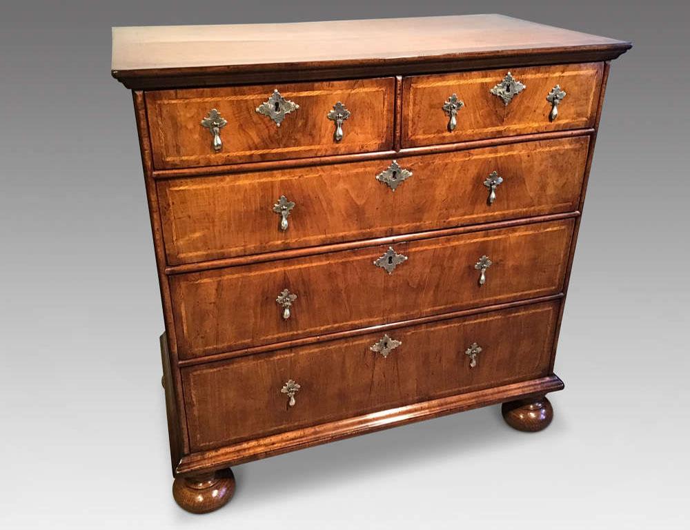 William and Mary walnut chest of drawers on bun feet with cross banding boxwood.