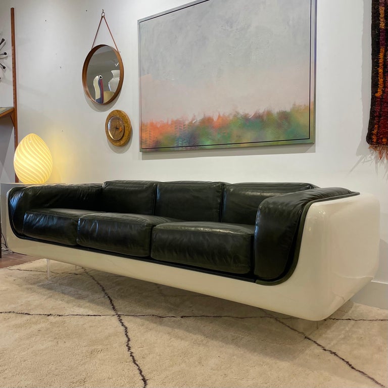 Exceptional piece designed by William Andrus for American furniture makers Steelcase, circa 1970’s. Fibreglass body has been newly refinished in Wimbledon White automotive paint, all new British Racing Green leather upholstery. Lucite base gives the