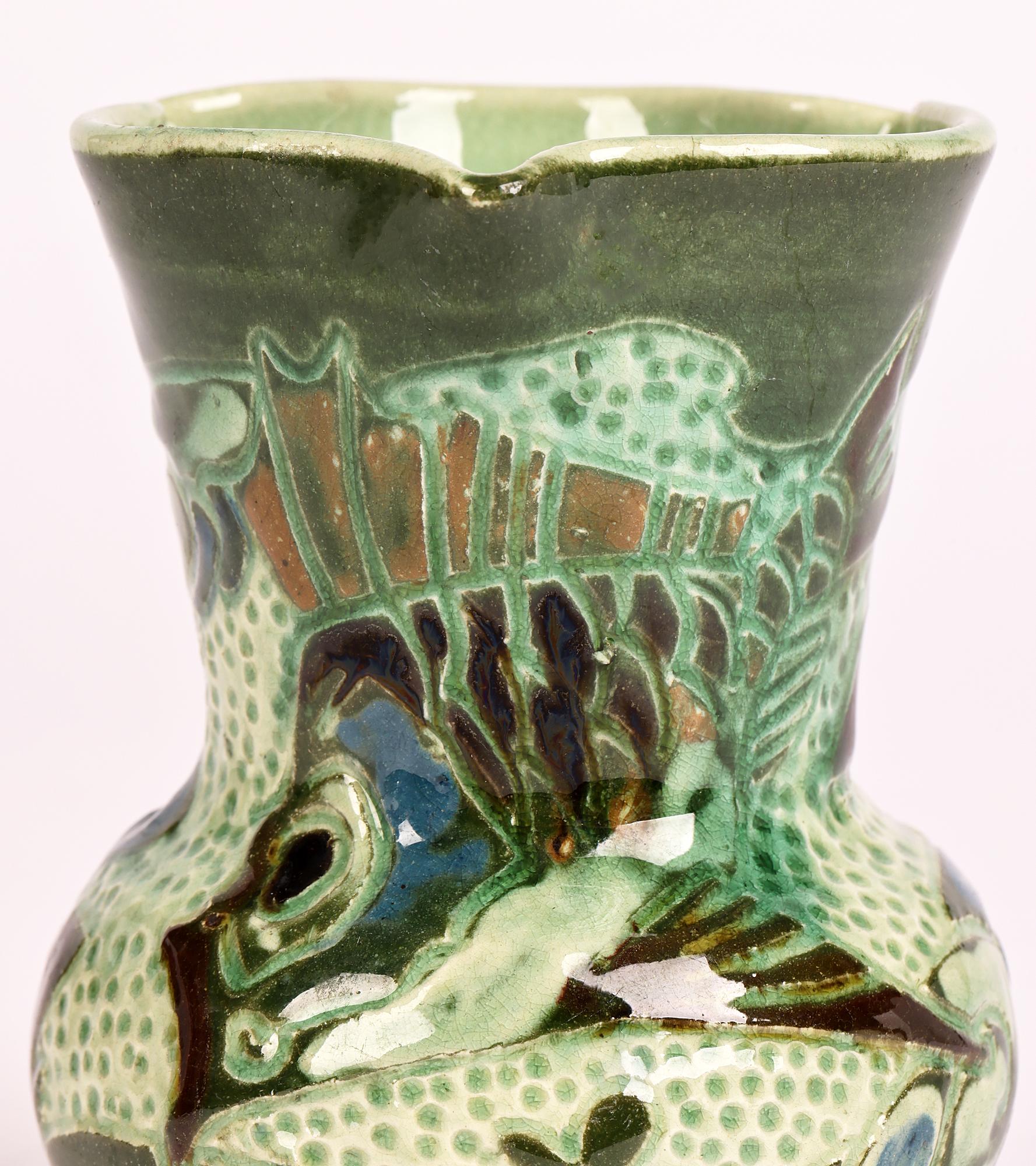 A delightful Devon art pottery vase decorated in sgraffito with a fish swimming amidst weed made in Barnstaple by renowned artist William Leonard Baron (British, 1863-1937) dating from around 1895. 

William Baron studied at Lambeth School of Art