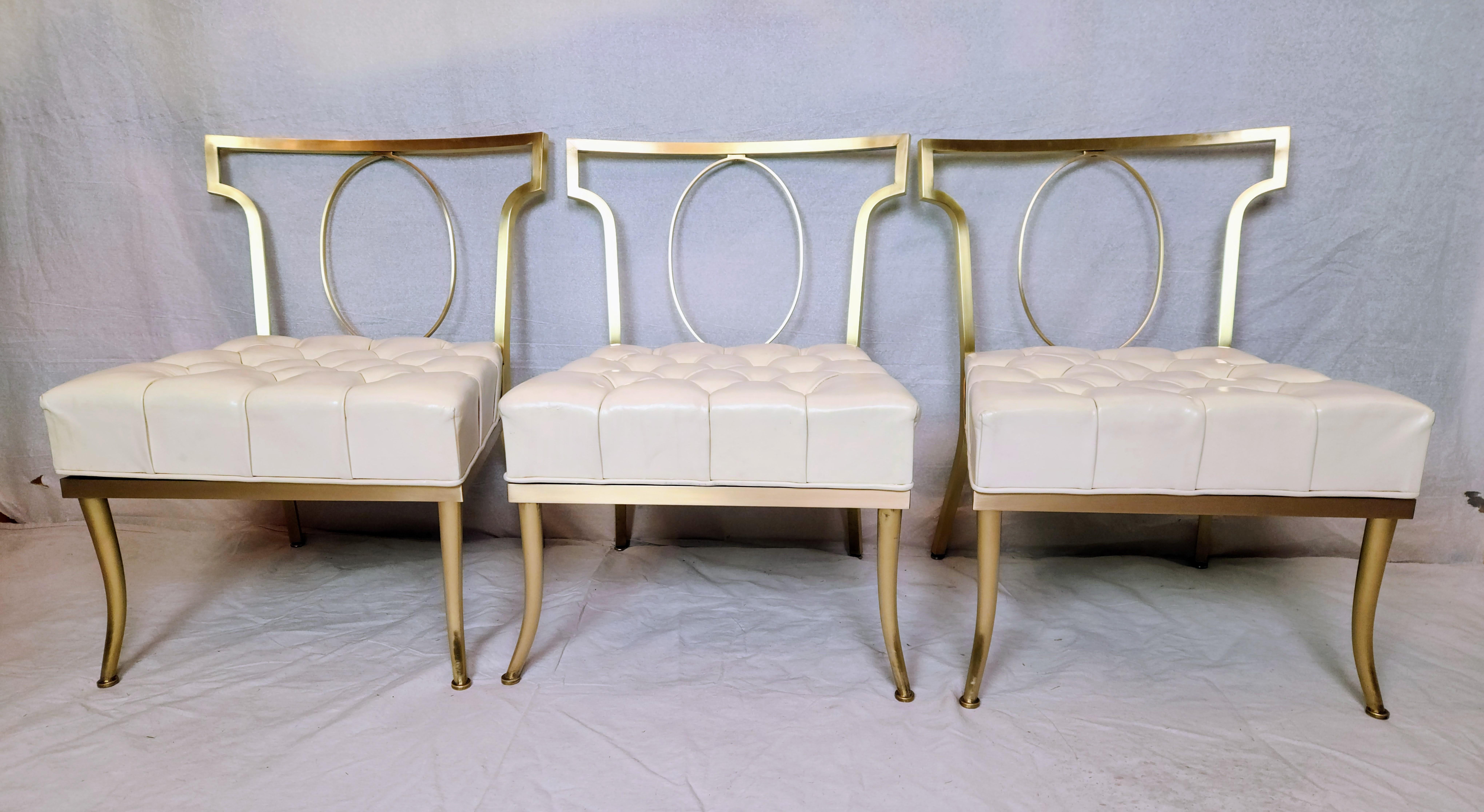 A set of three brass slipper chairs blending classical form with modernist purity with a 42